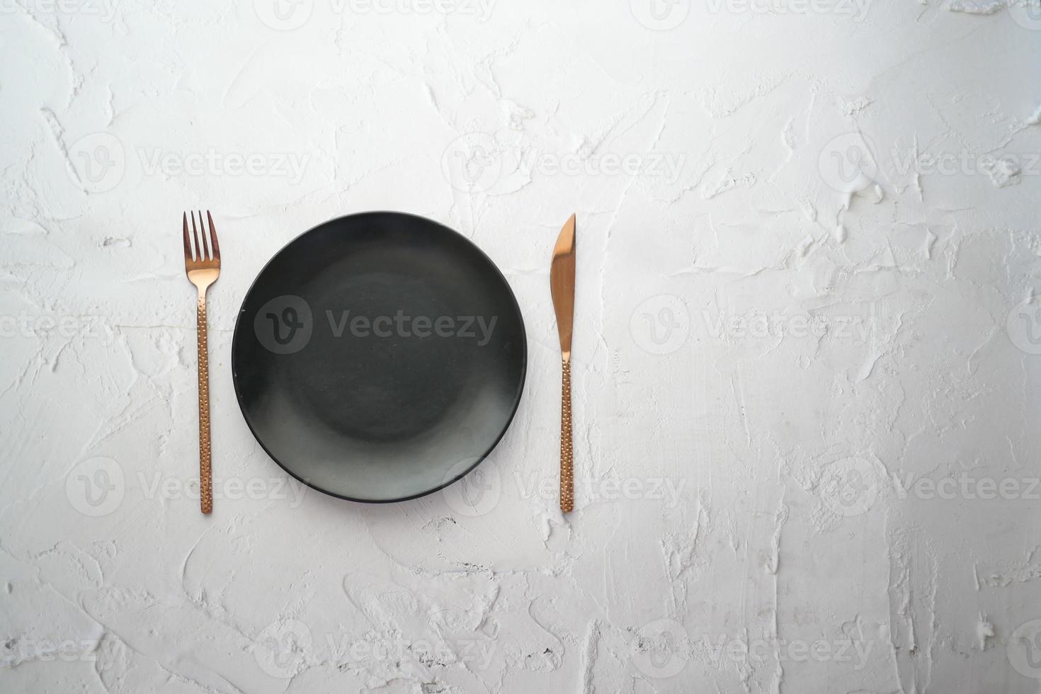 cutlery and empty plate on wooden background top down photo