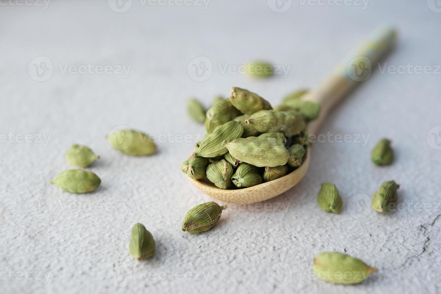 close up of Cardamom on a spoon on table photo