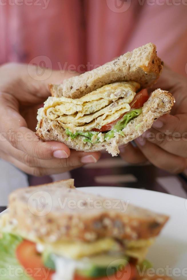 sándwich de huevo hecho con pan integral, tomate y lechuga en la mesa foto