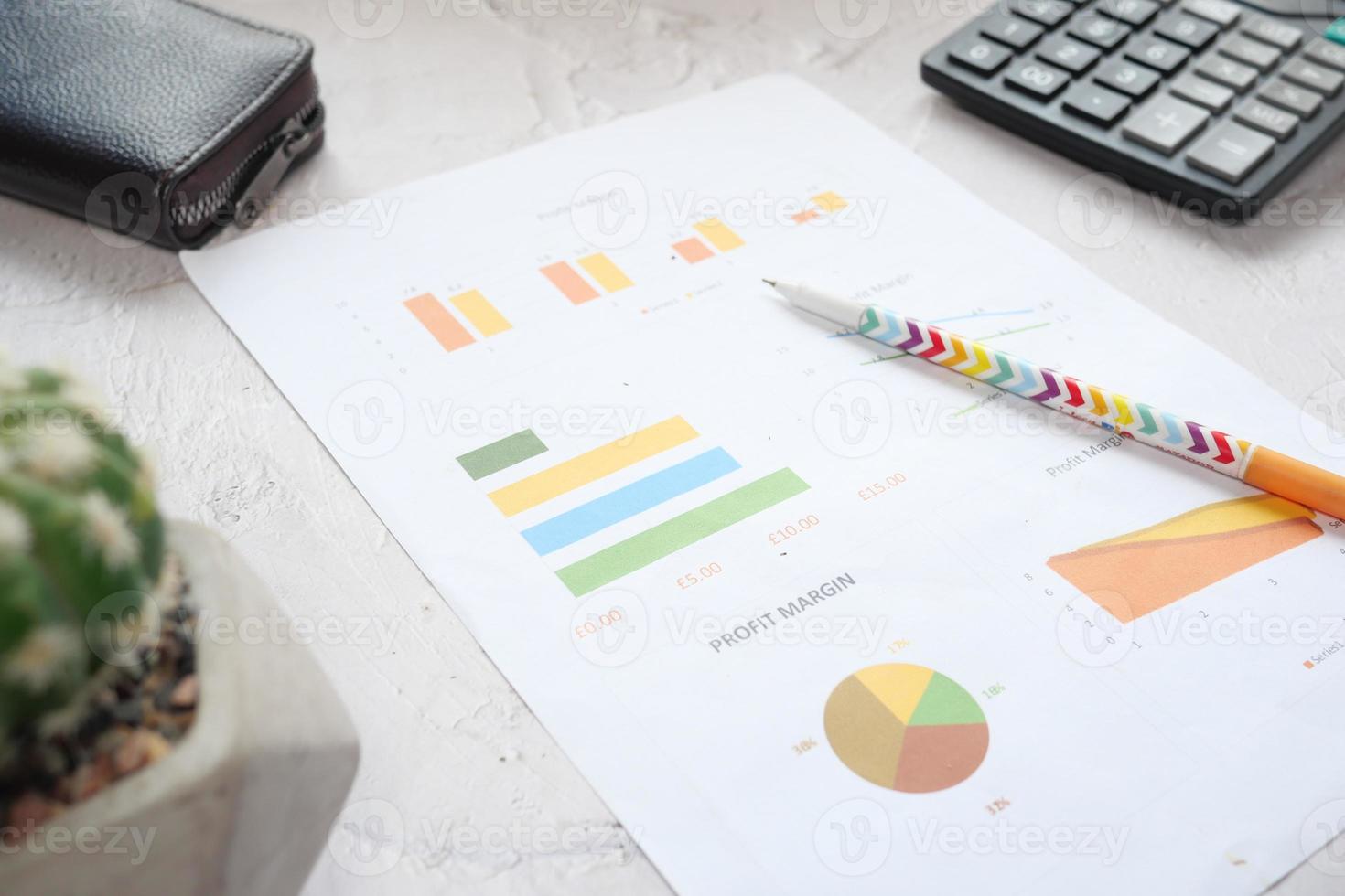 close up of financial charts and pen on table photo