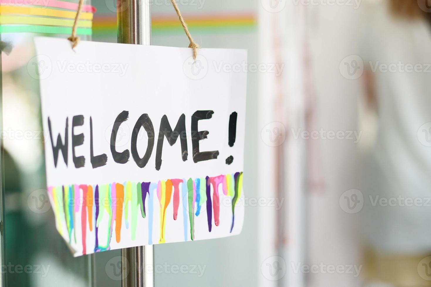 welcome hand written text on paper hanging on cafe door photo