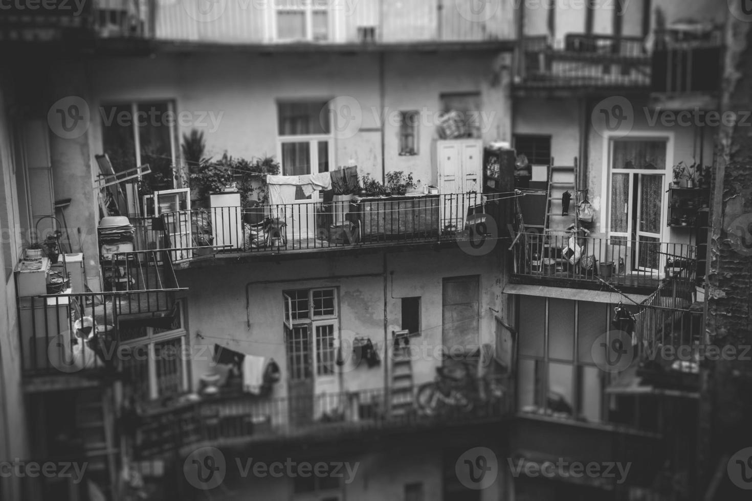 Facade apartment building with shared balconies, many old things, low living standards photo