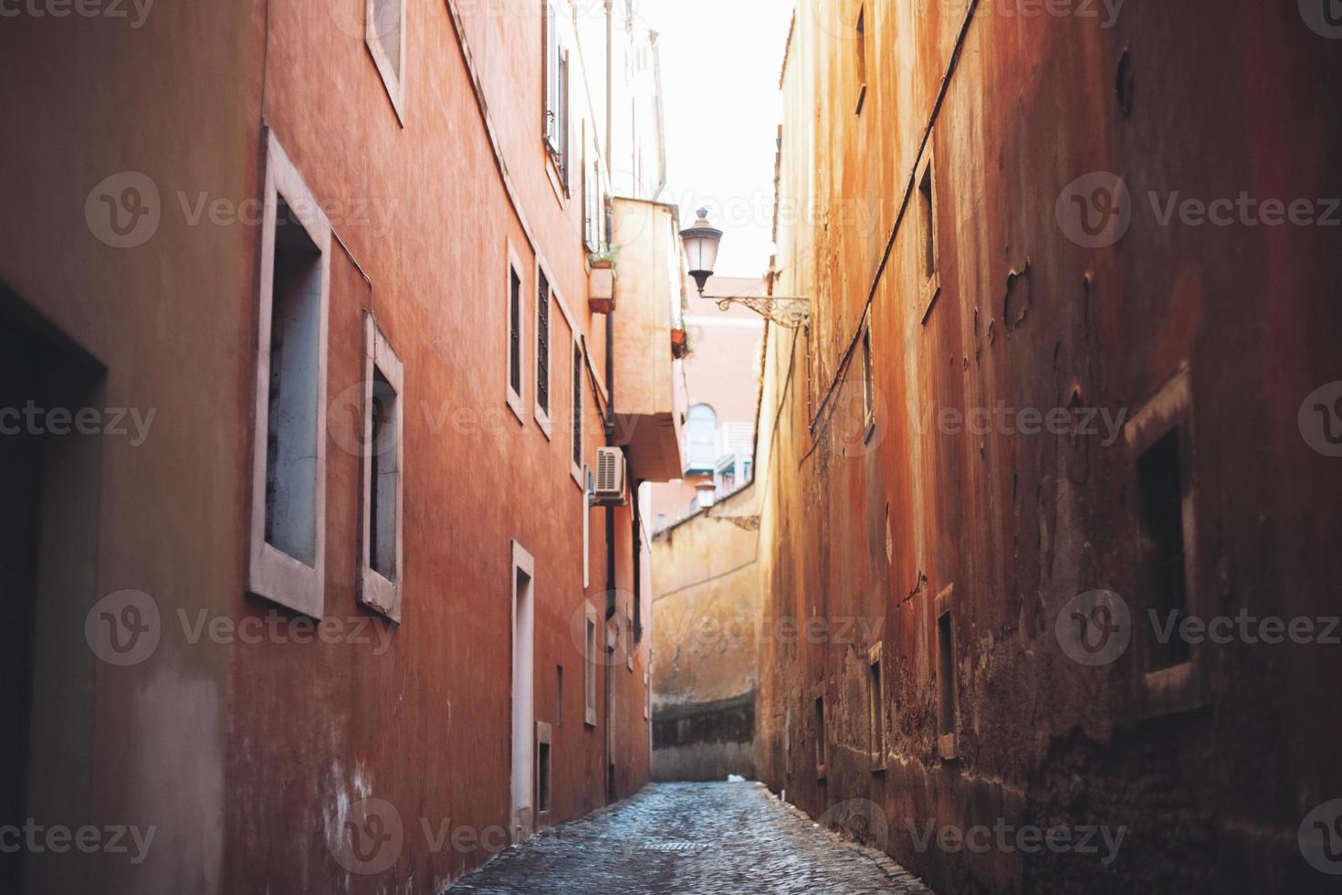 empty narrow city street made of cobblestones between old houses. photo