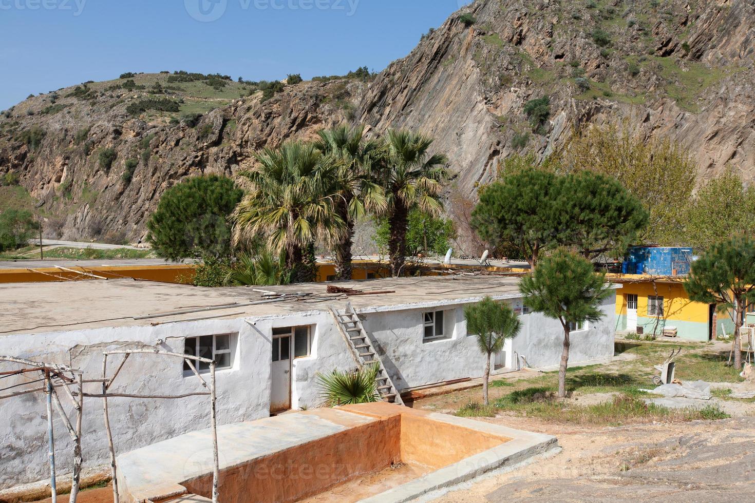 a poor house in a village in the middle of mountains between palm trees in Turkey. photo