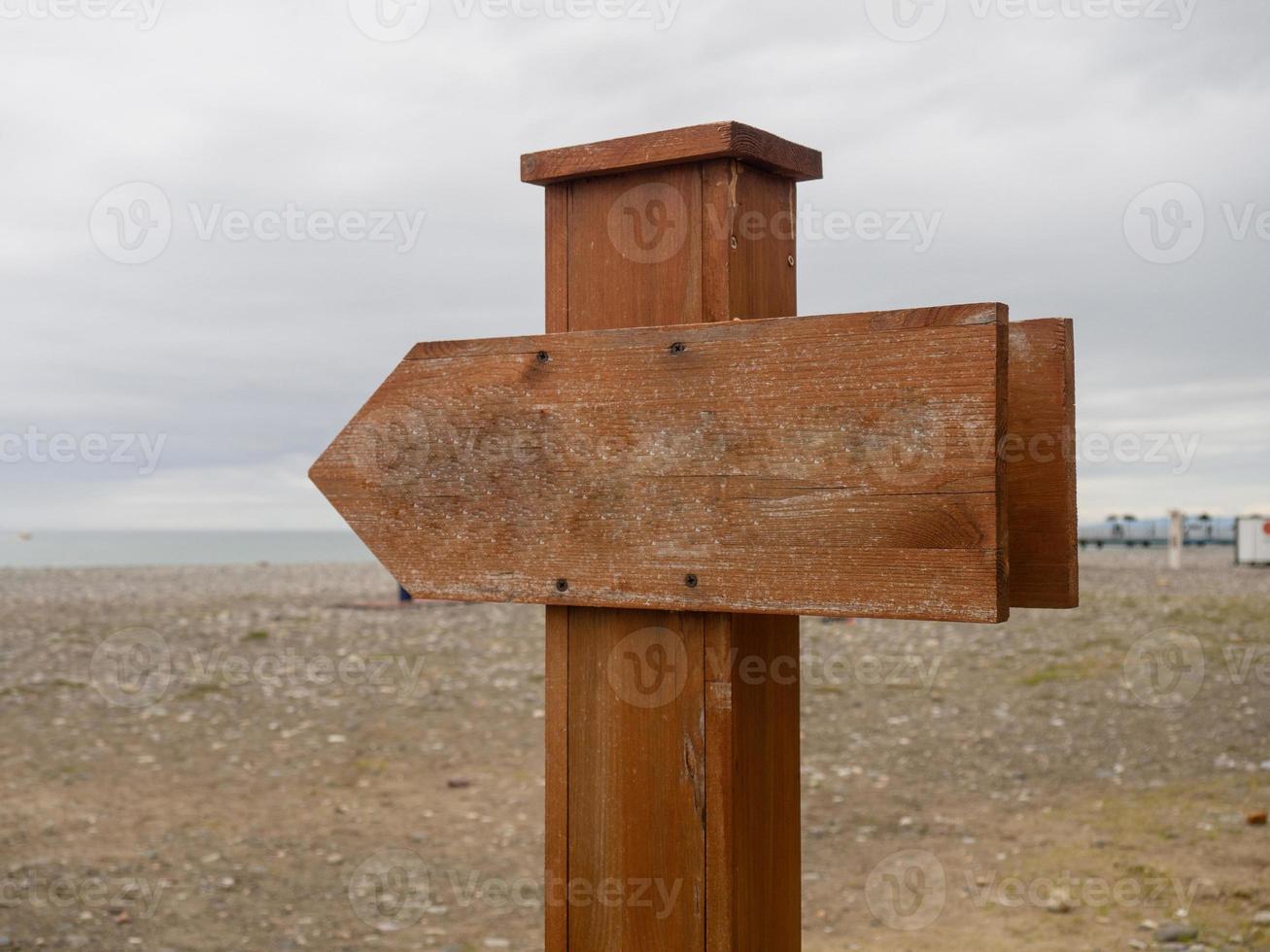 Wooden pointer on the beach. Mockup in nature. Recreation and tourism. photo