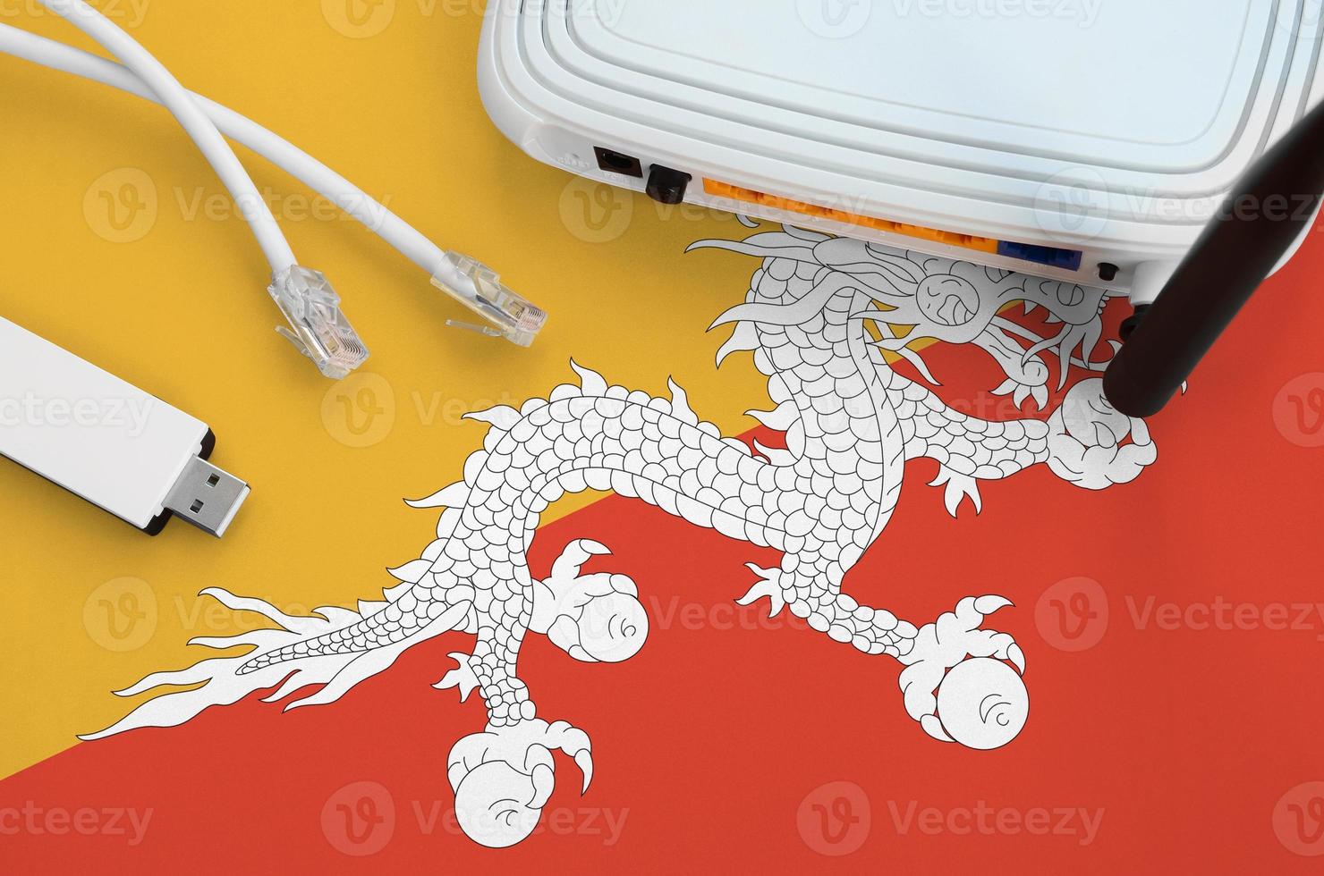 Bhutan flag depicted on table with internet rj45 cable, wireless usb wifi adapter and router. Internet connection concept photo
