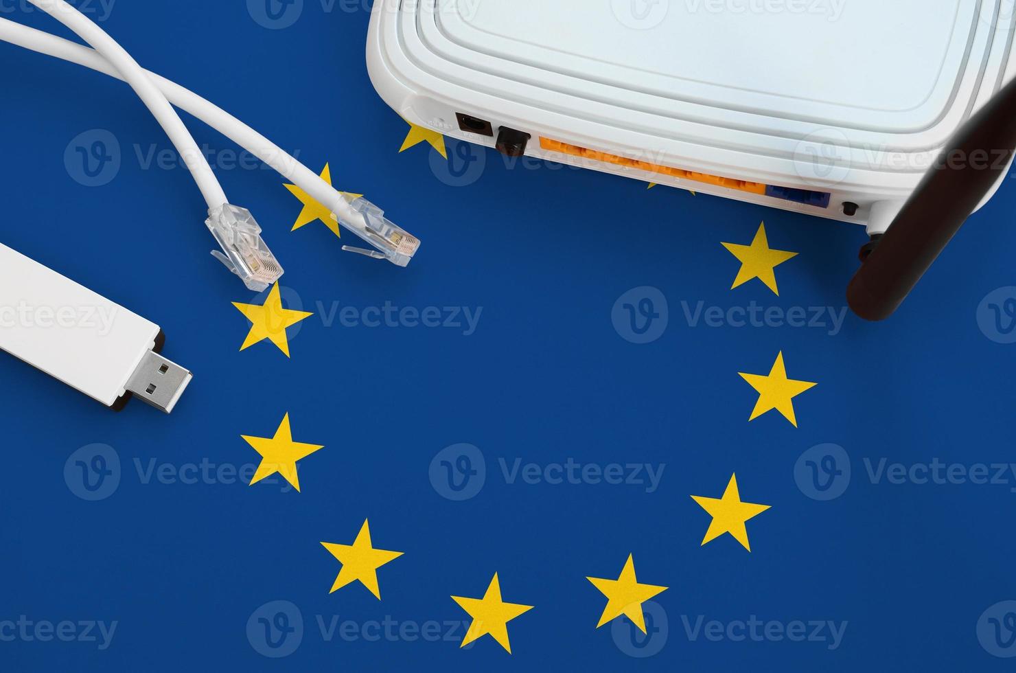 European union flag depicted on table with internet rj45 cable, wireless usb wifi adapter and router. Internet connection concept photo