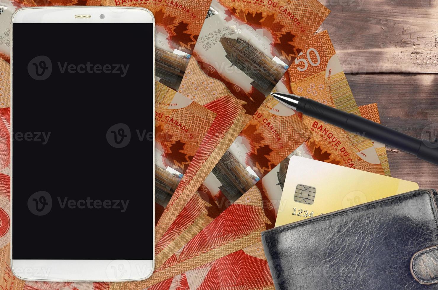 50 Canadian dollars bills and smartphone with purse and credit card. E-payments or e-commerce concept. Online shopping and business with portable devices photo