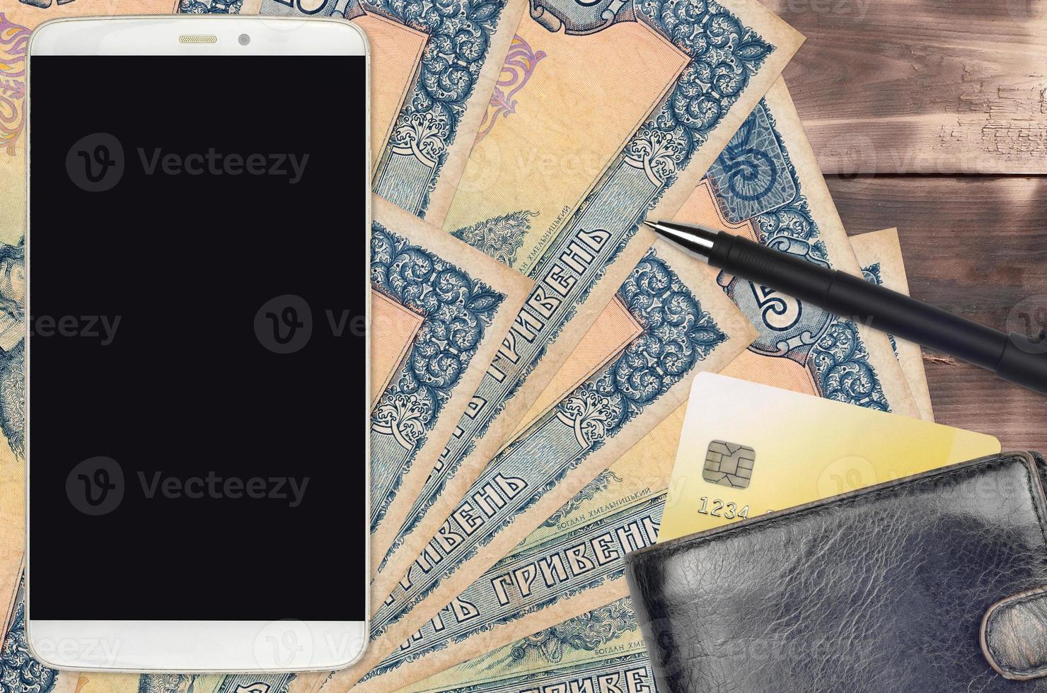 5 Ukrainian hryvnias bills and smartphone with purse and credit card. E-payments or e-commerce concept. Online shopping and business with portable devices photo