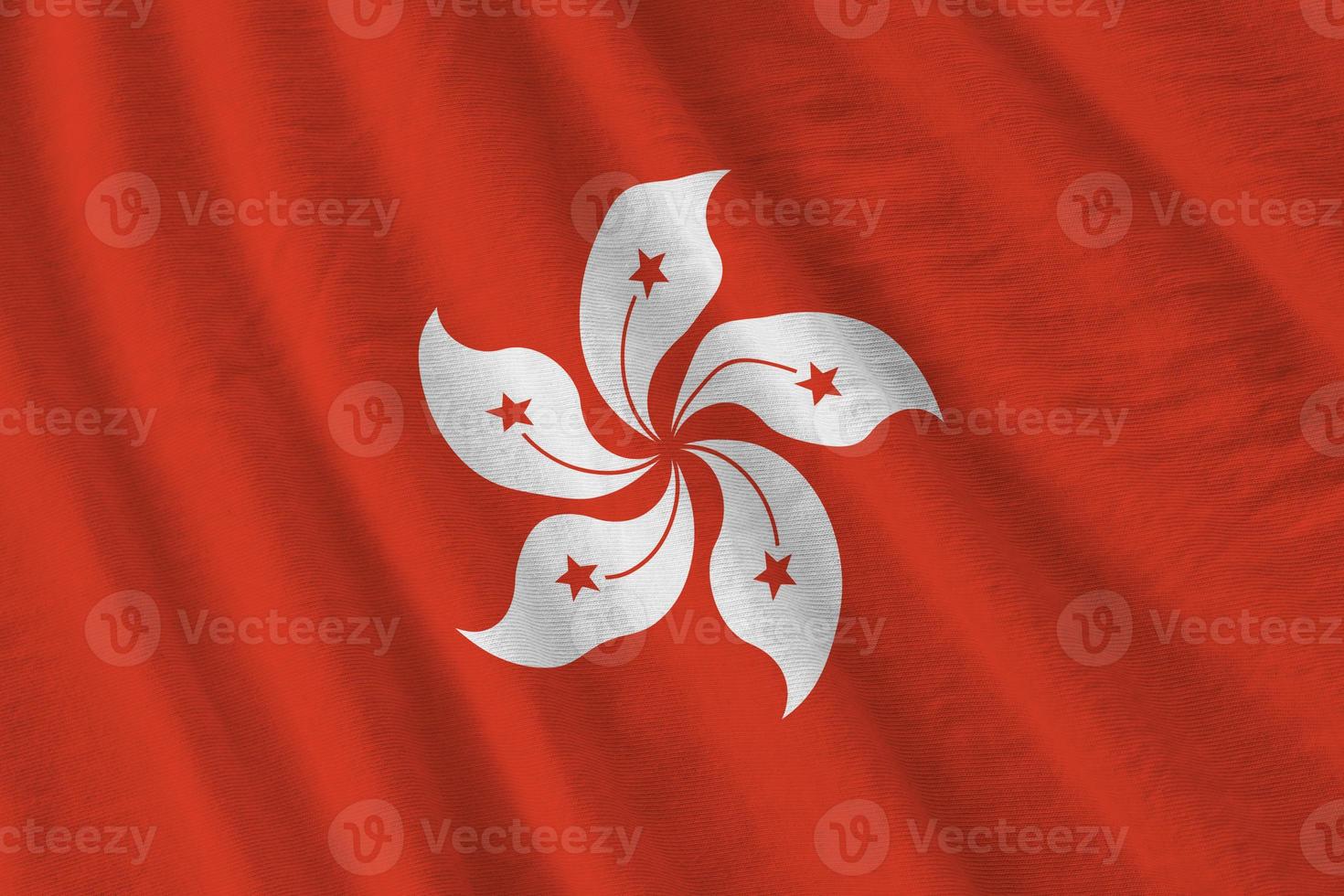 Hong kong flag with big folds waving close up under the studio light indoors. The official symbols and colors in banner photo