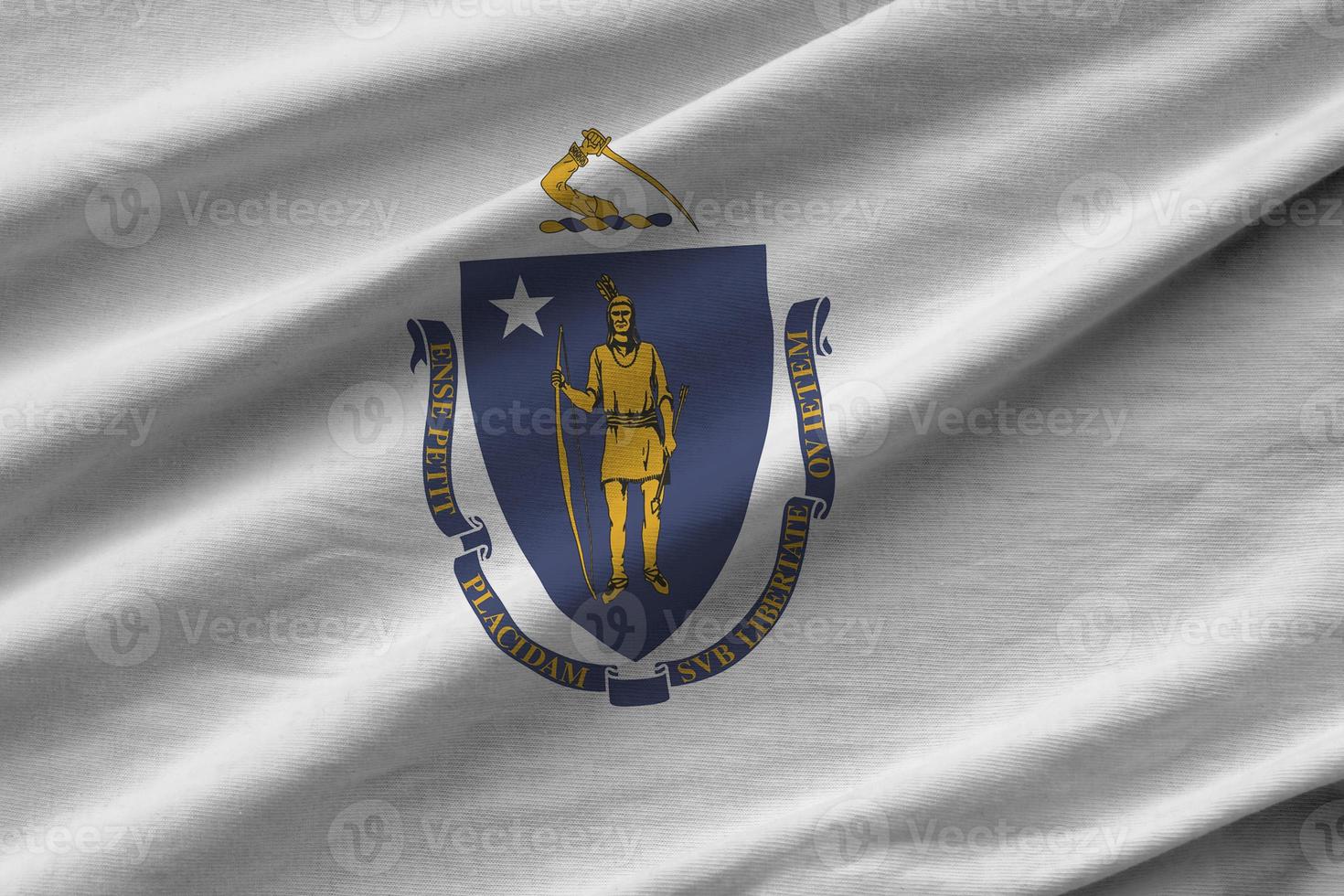 Massachusetts US state flag with big folds waving close up under the studio light indoors. The official symbols and colors in banner photo