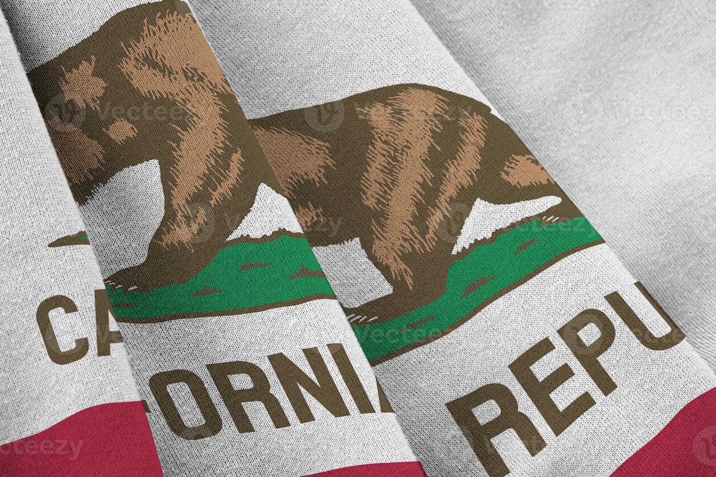 California US state flag with big folds waving close up under the studio light indoors. The official symbols and colors in banner photo