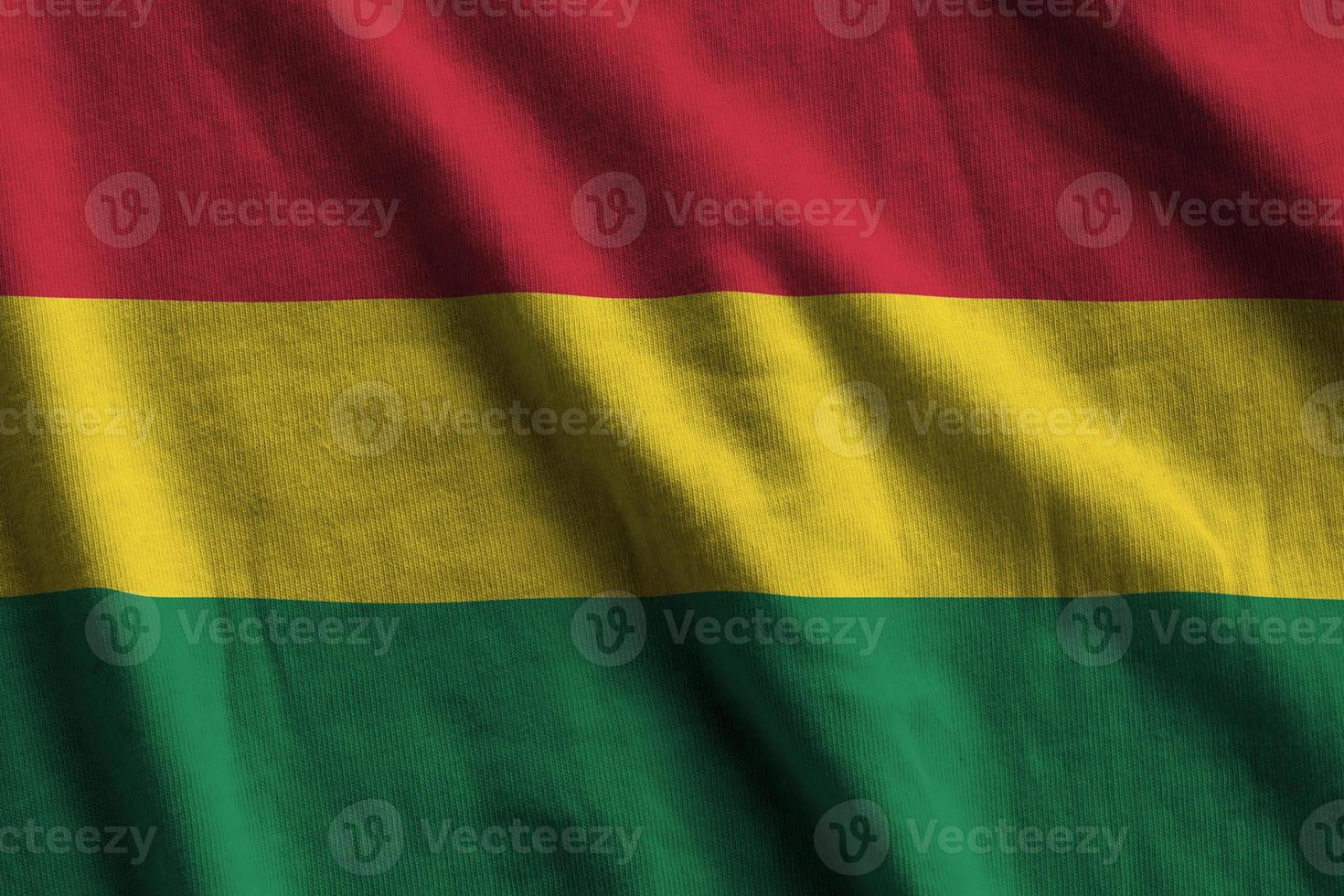 Bolivia flag with big folds waving close up under the studio light indoors. The official symbols and colors in banner photo