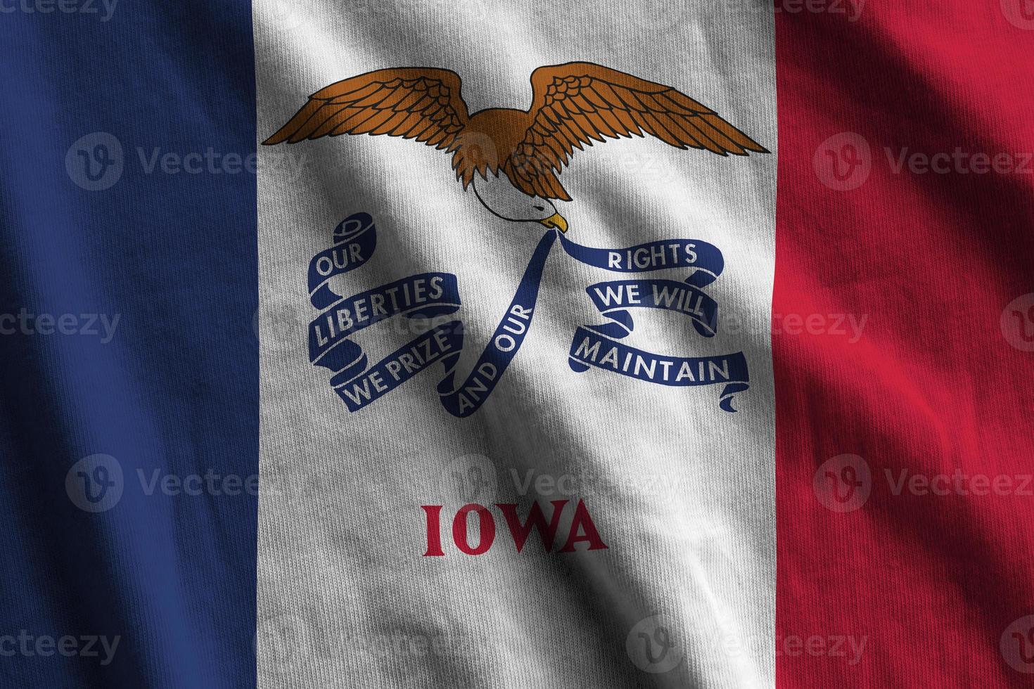Iowa US state flag with big folds waving close up under the studio light indoors. The official symbols and colors in banner photo