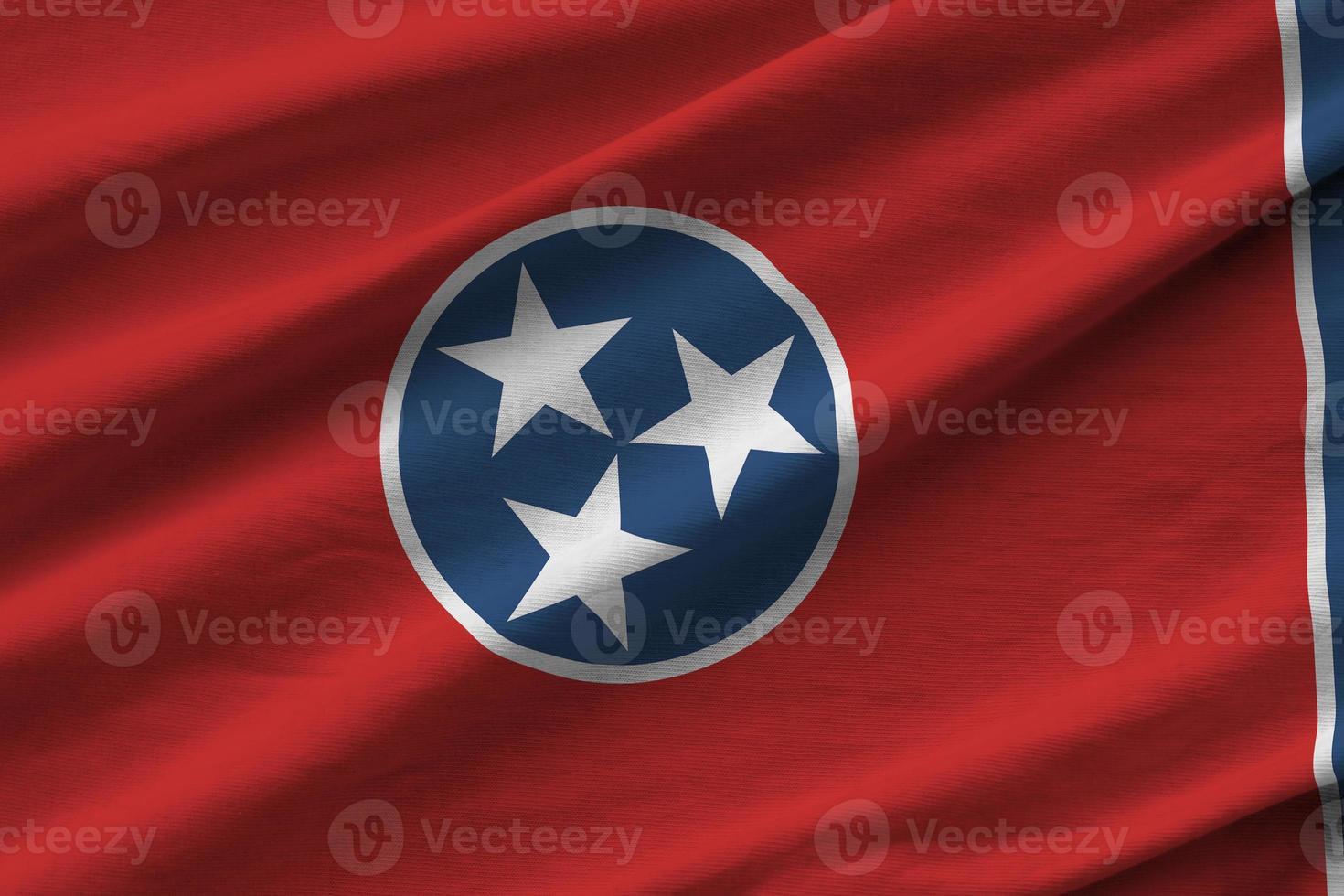 Tennessee US state flag with big folds waving close up under the studio light indoors. The official symbols and colors in banner photo