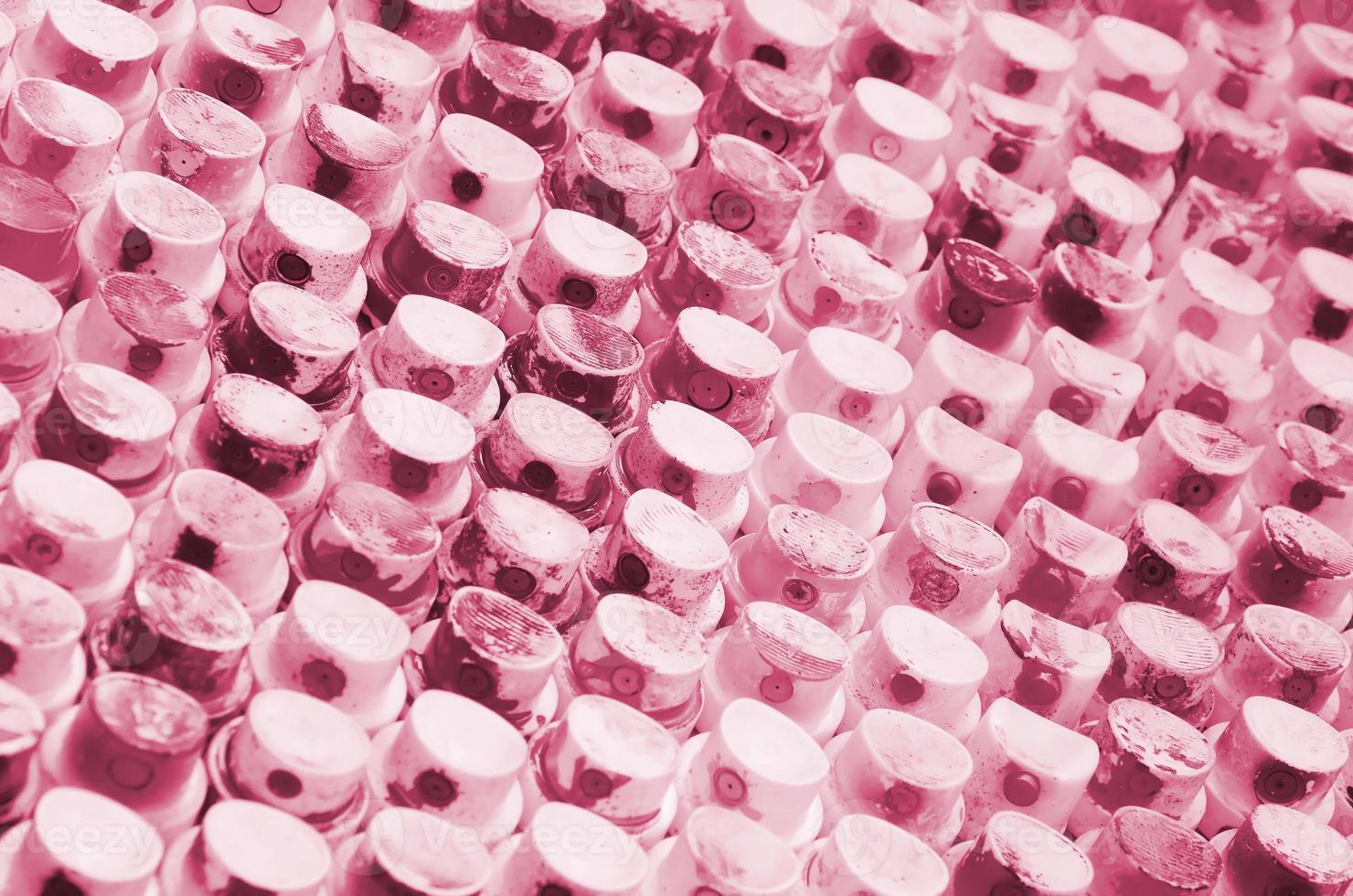 A pattern from a many nozzles from a paint sprayer for drawing graffiti, smeared into different colors. Image toned in Viva Magenta, color of the year photo