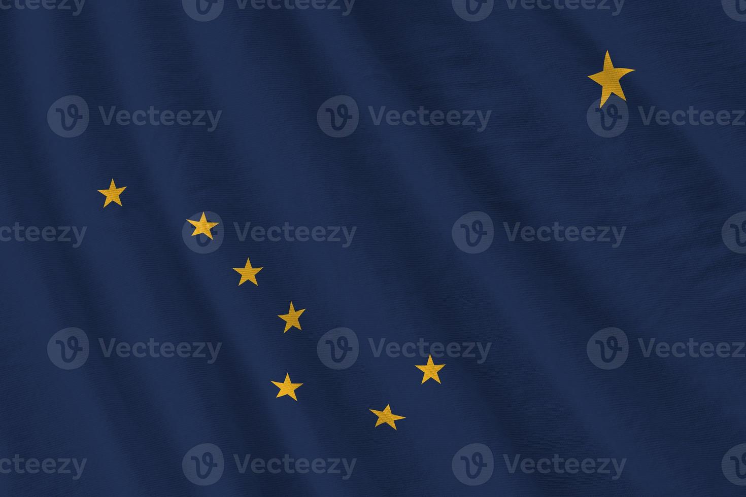 Alaska US state flag with big folds waving close up under the studio light indoors. The official symbols and colors in banner photo