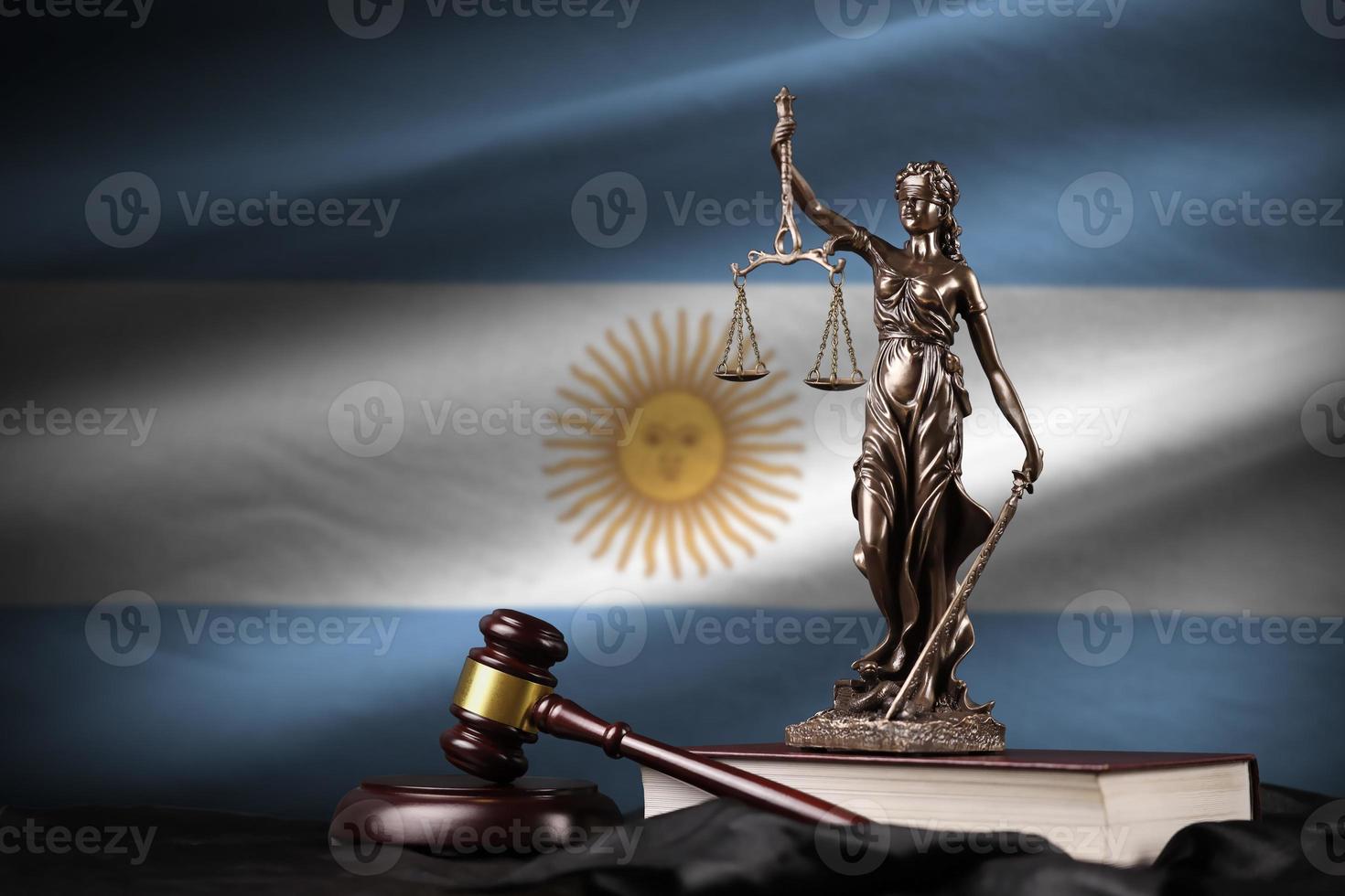 Argentina flag with statue of lady justice, constitution and judge hammer on black drapery. Concept of judgement and guilt photo