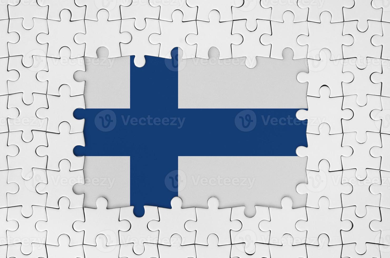 Finland flag in frame of white puzzle pieces with missing central part photo