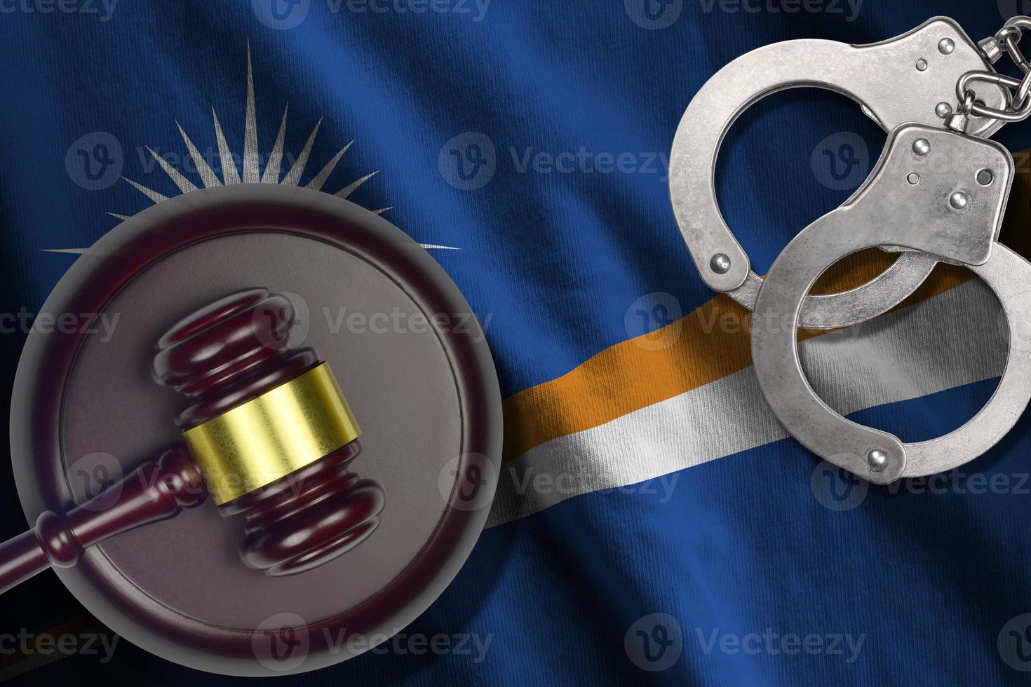 Marshall Islands flag with judge mallet and handcuffs in dark room. Concept of criminal and punishment, background for judgement topics photo