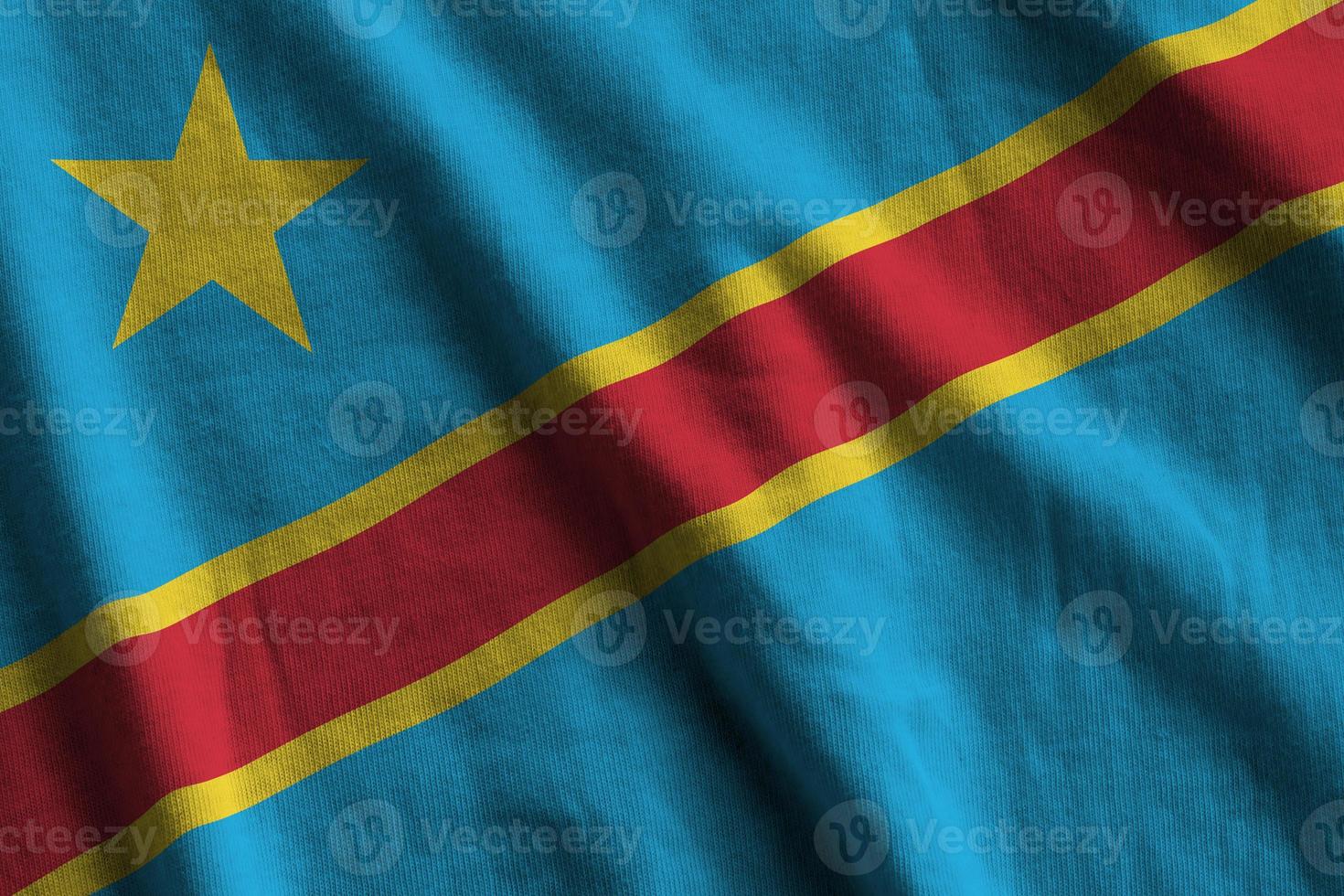 Democratic Republic of the Congo flag with big folds waving close up under the studio light indoors. The official symbols and colors in banner photo