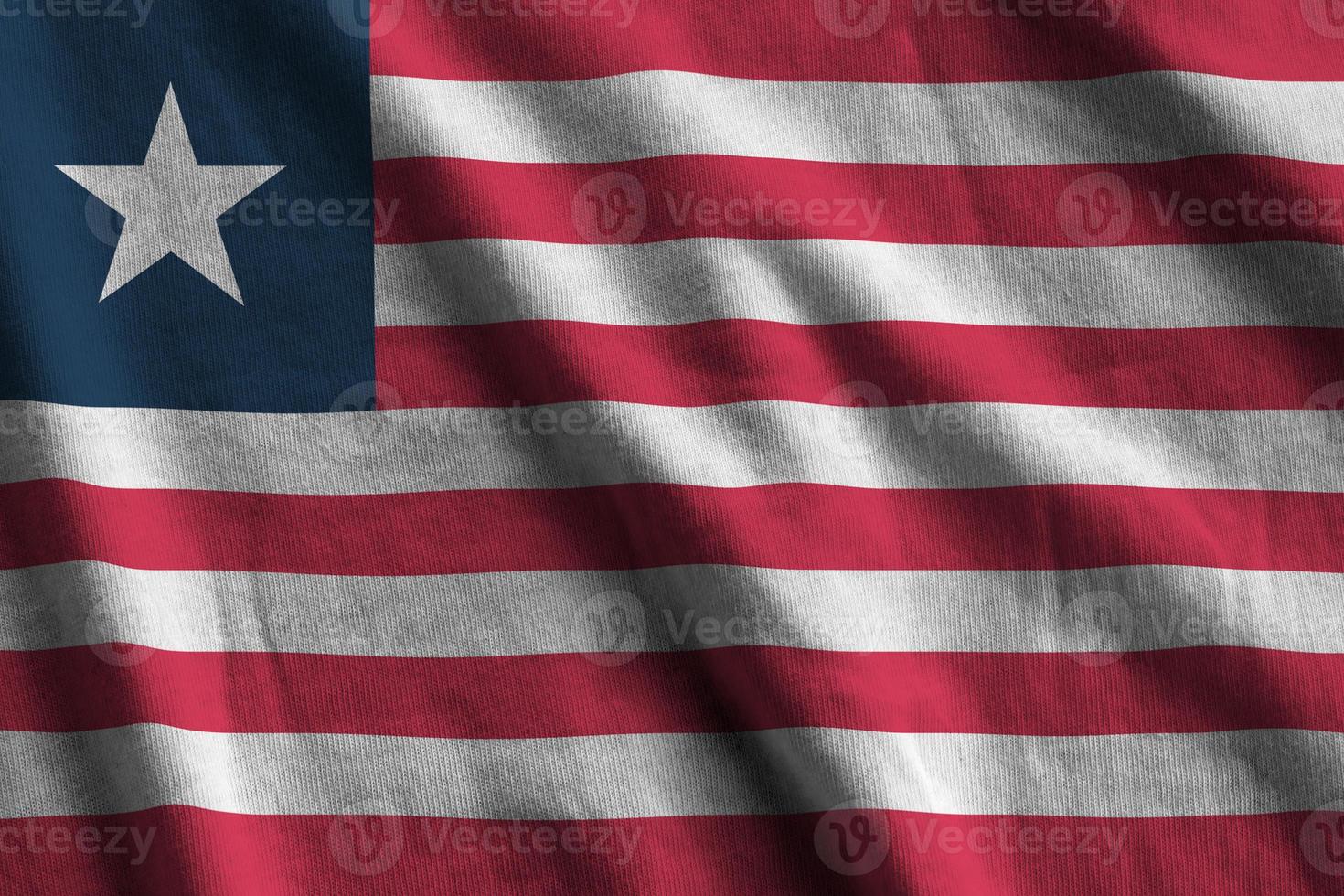 Liberia flag with big folds waving close up under the studio light indoors. The official symbols and colors in banner photo