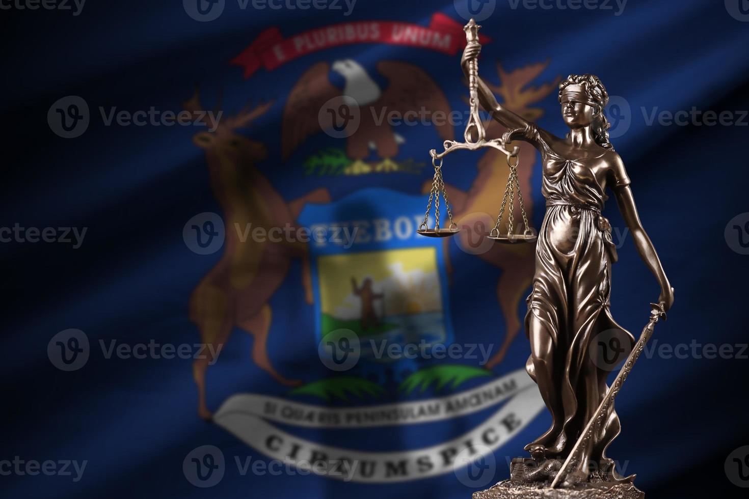 Michigan US state flag with statue of lady justice and judicial scales in dark room. Concept of judgement and punishment photo