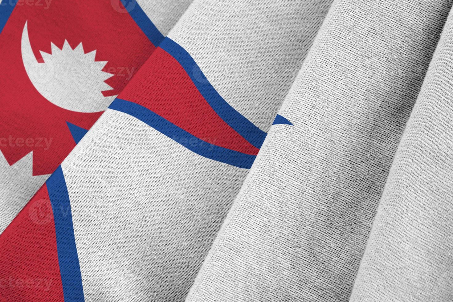 Nepal flag with big folds waving close up under the studio light indoors. The official symbols and colors in banner photo