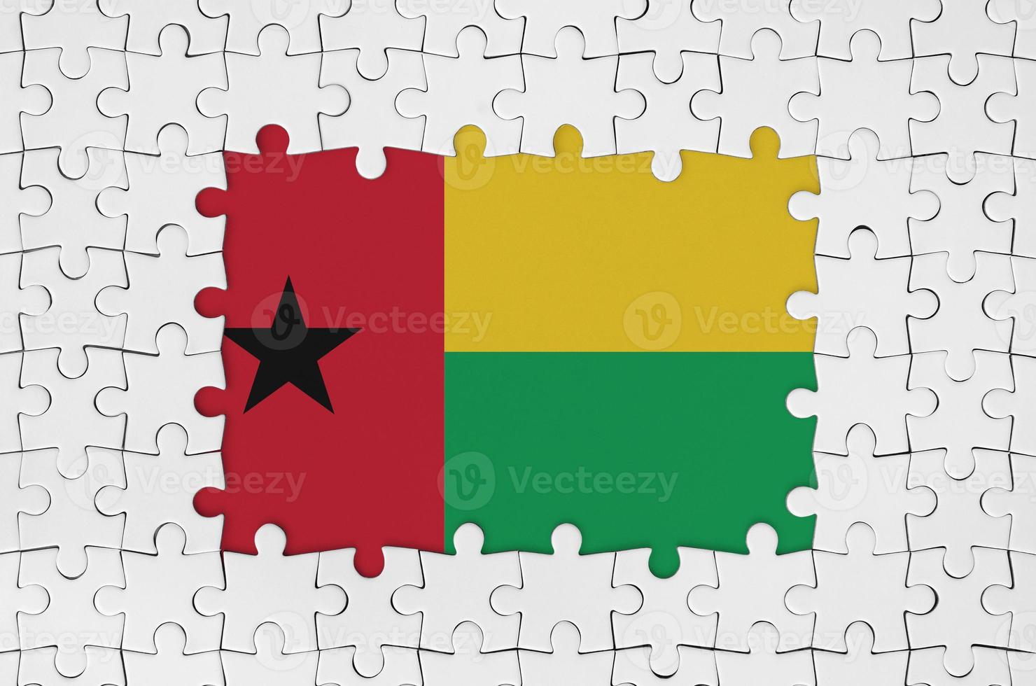 Guinea Bissau flag in frame of white puzzle pieces with missing central part photo
