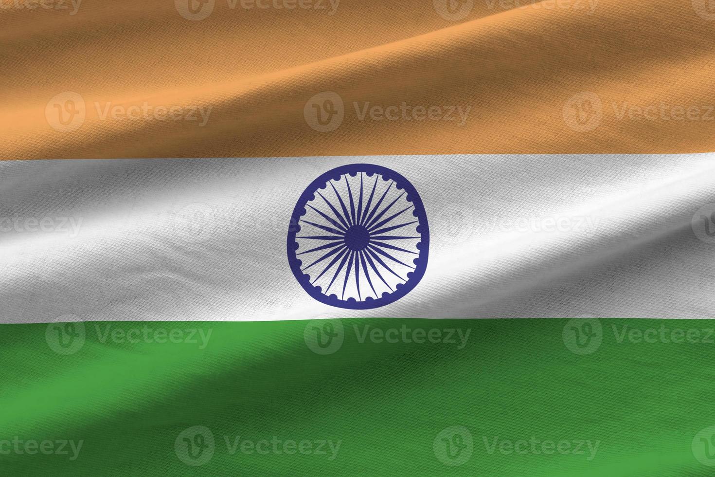 India flag with big folds waving close up under the studio light indoors. The official symbols and colors in banner photo