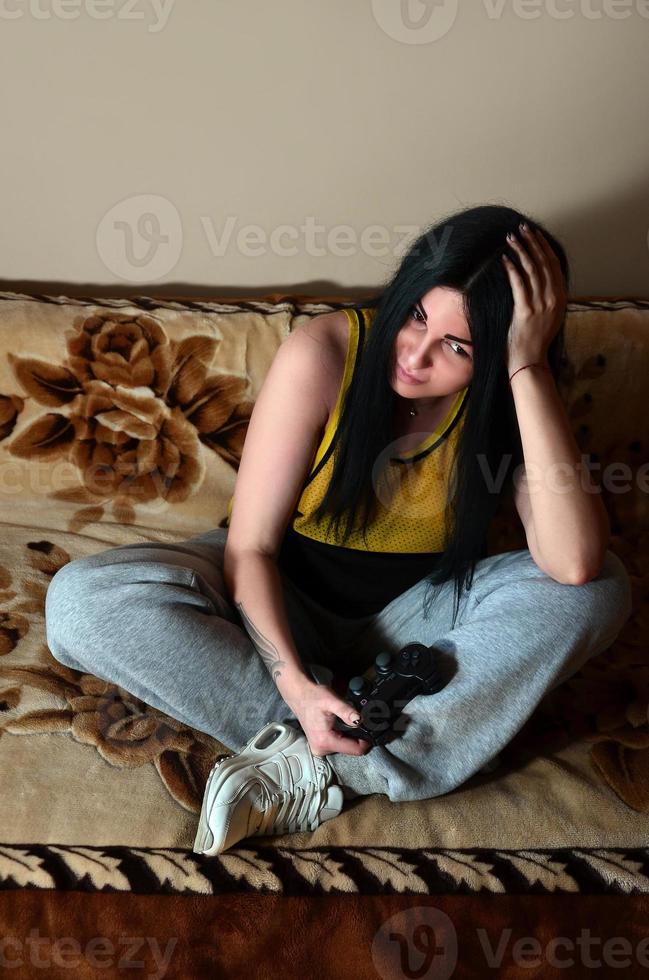 The young girl sitting on the couch is disappointed by the loss photo