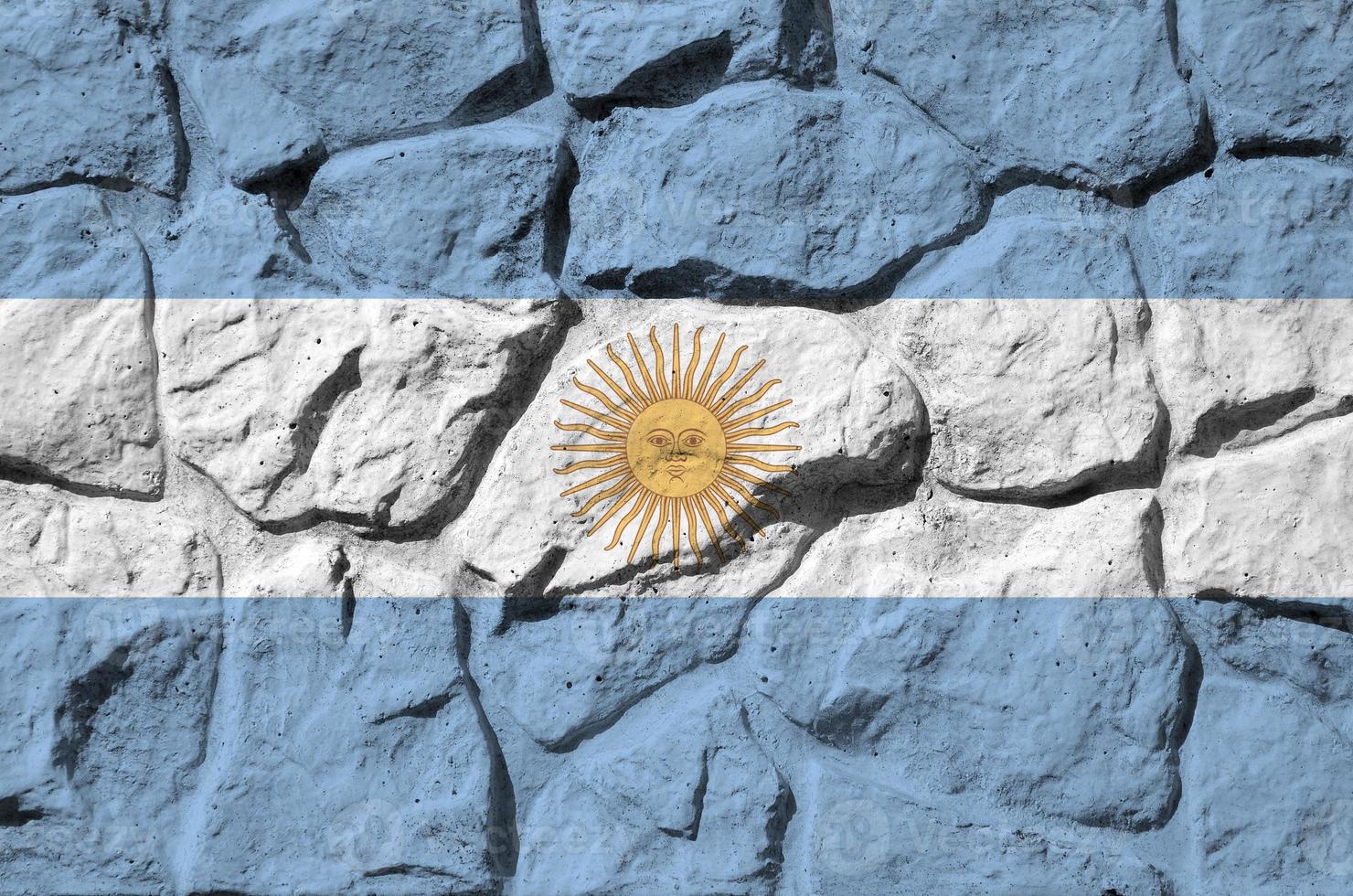 bandera argentina representada en colores de pintura en el primer plano de la pared de piedra antigua. banner texturizado sobre fondo de pared de roca foto
