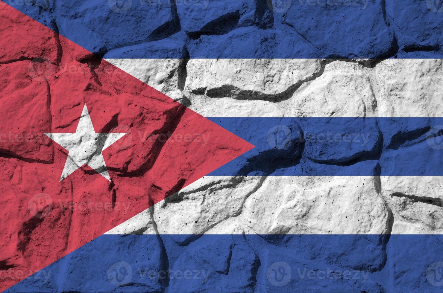 Cuba flag depicted in paint colors on old stone wall closeup. Textured banner on rock wall background photo