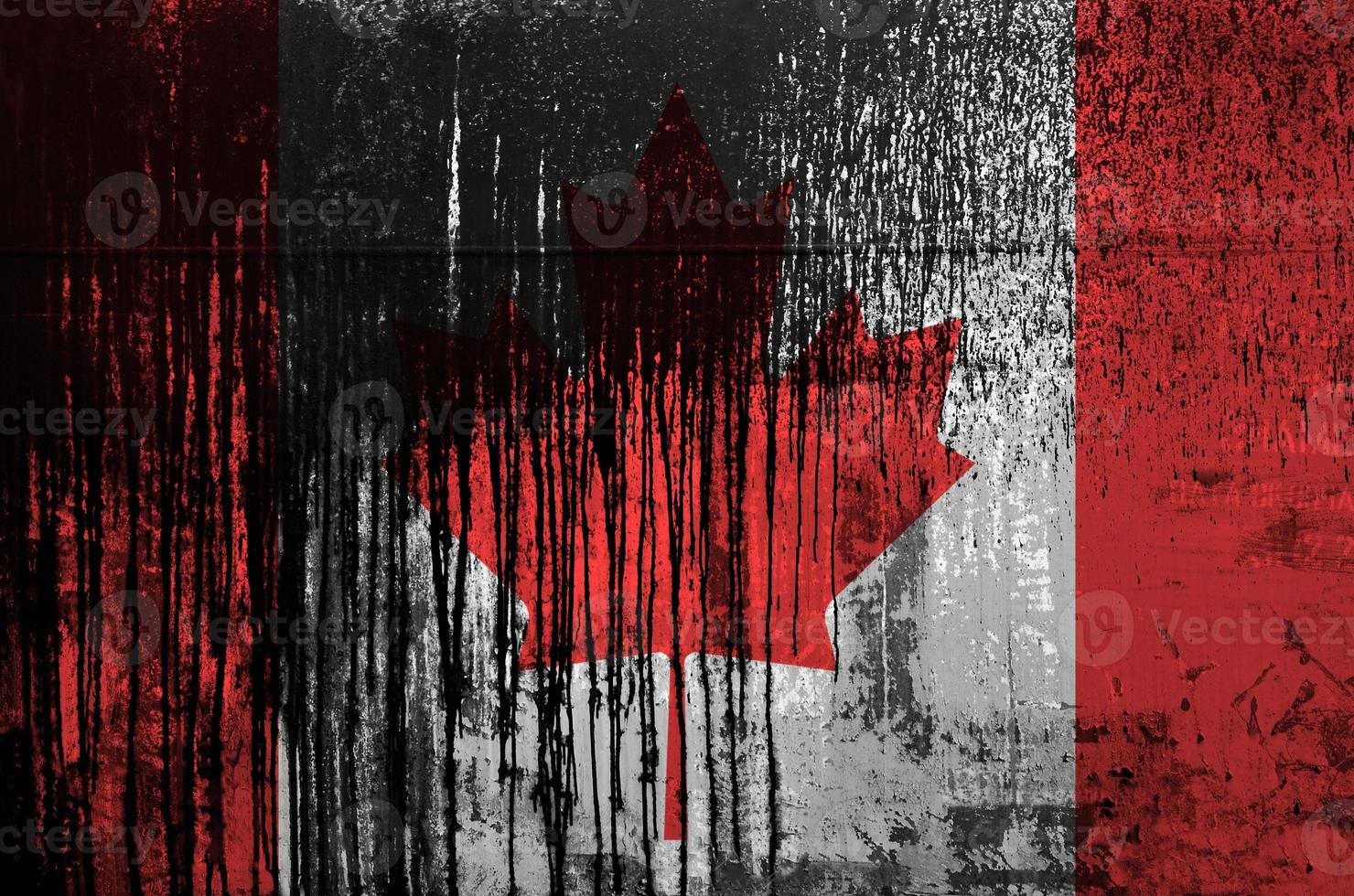 Canada flag depicted in paint colors on old and dirty oil barrel wall closeup. Textured banner on rough background photo