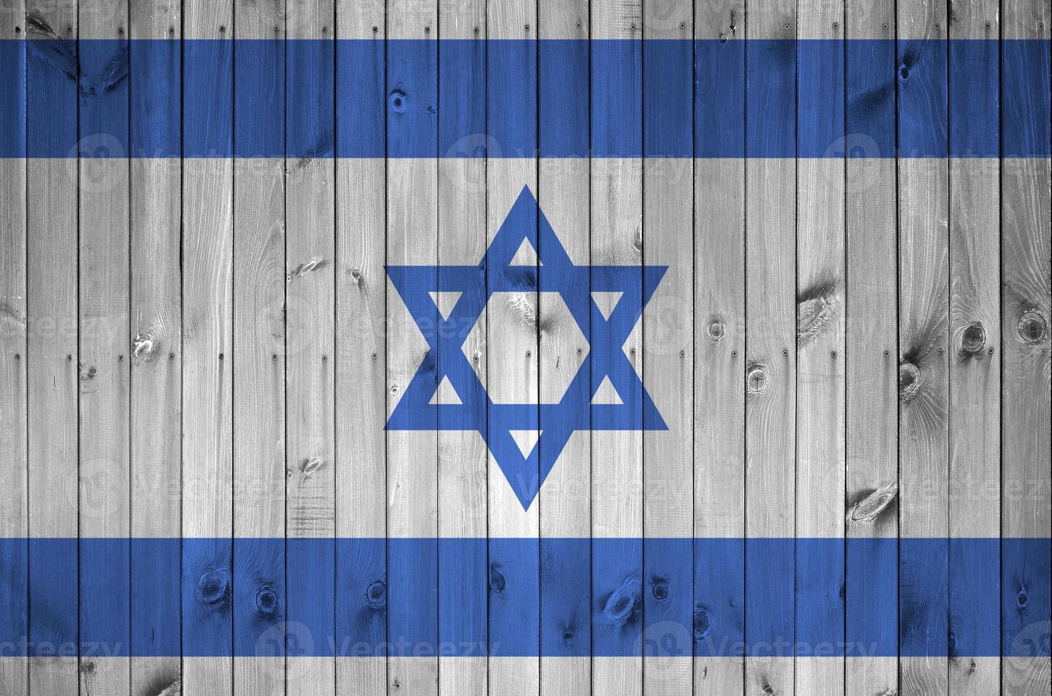 Israel flag depicted in bright paint colors on old wooden wall. Textured banner on rough background photo