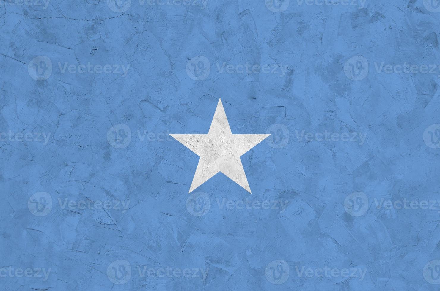 Somalia flag depicted in bright paint colors on old relief plastering wall. Textured banner on rough background photo