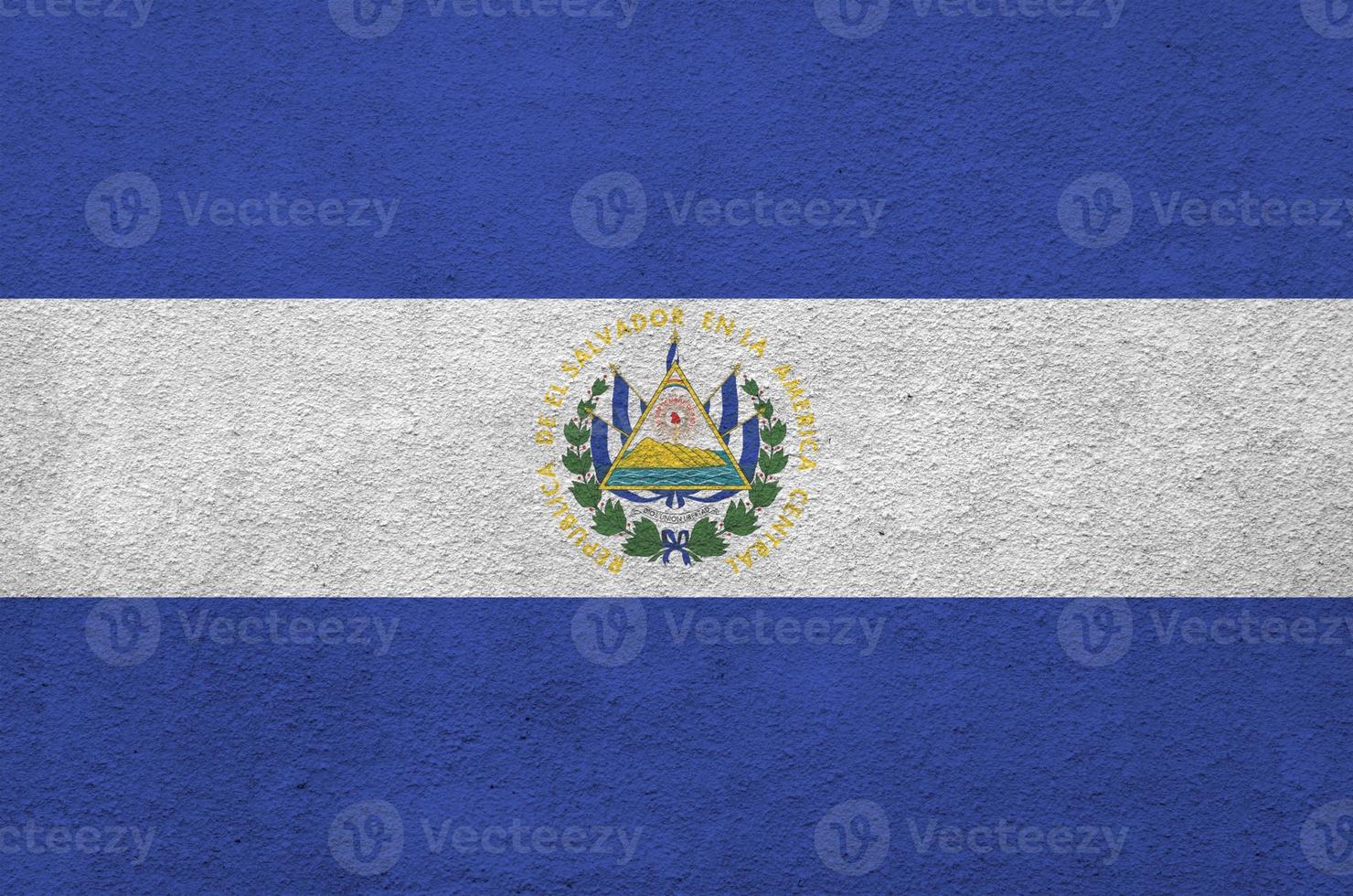 El Salvador flag depicted in bright paint colors on old relief plastering wall. Textured banner on rough background photo