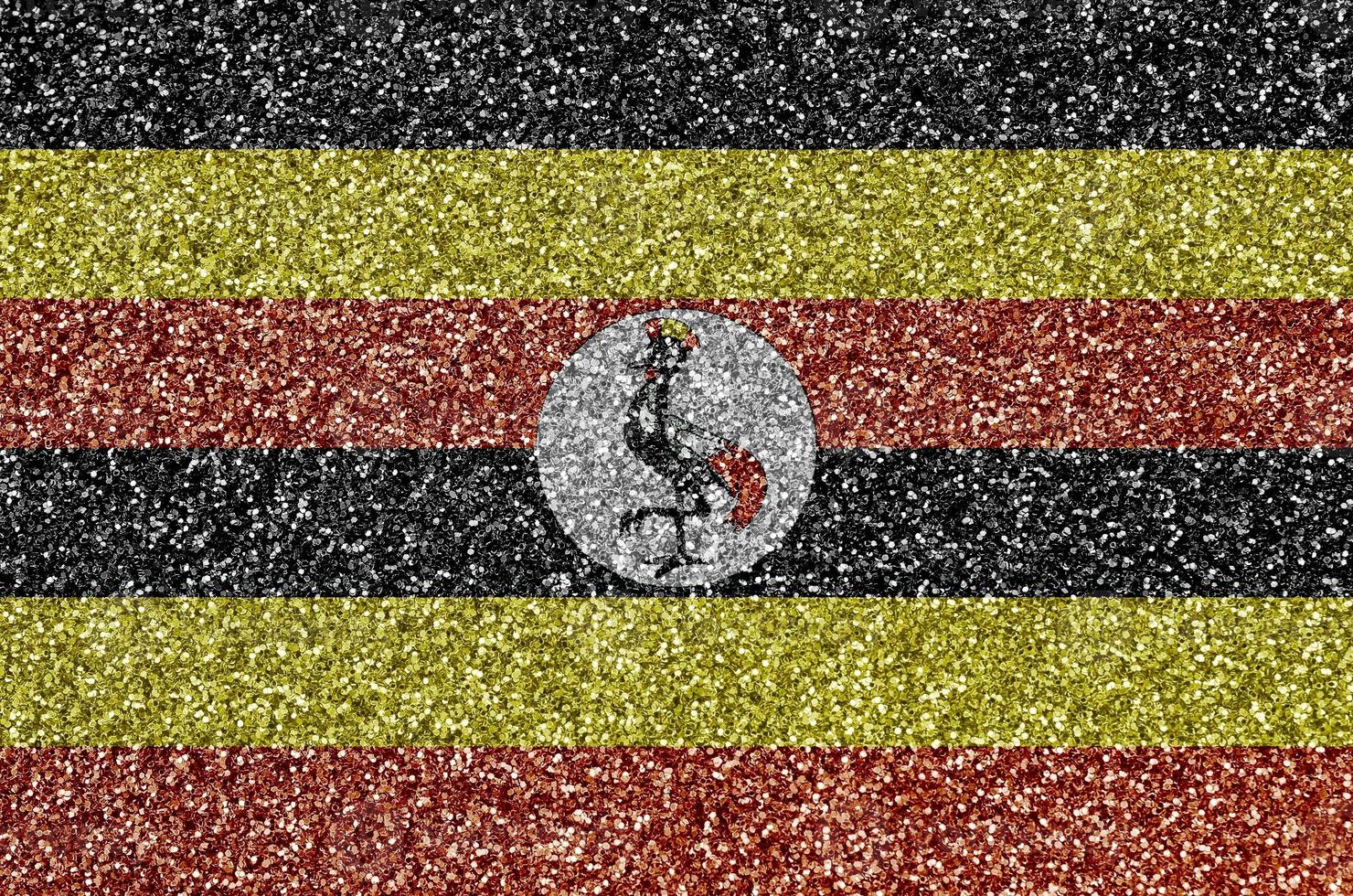 Uganda flag depicted on many small shiny sequins. Colorful festival background for party photo