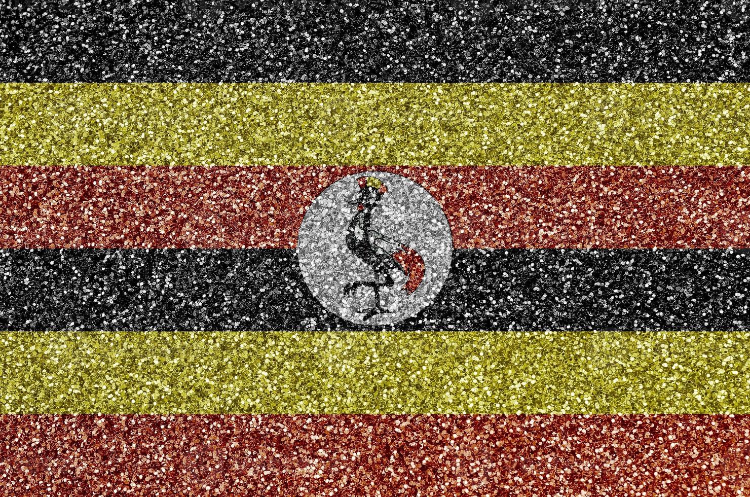 Uganda flag depicted on many small shiny sequins. Colorful festival background for party photo