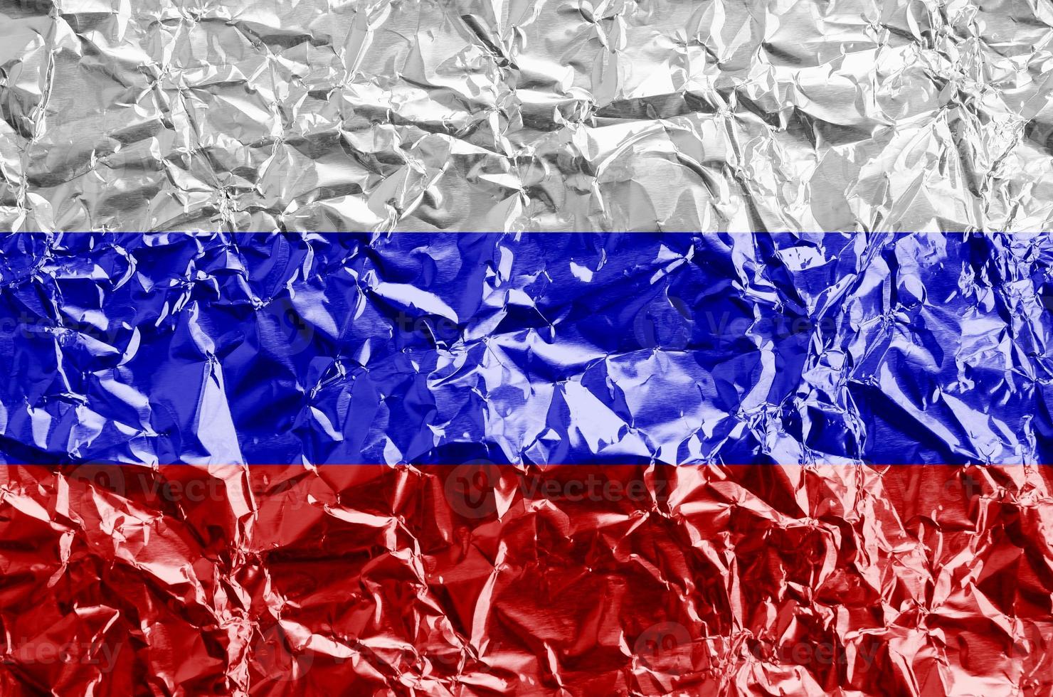Russia flag depicted in paint colors on shiny crumpled aluminium foil closeup. Textured banner on rough background photo
