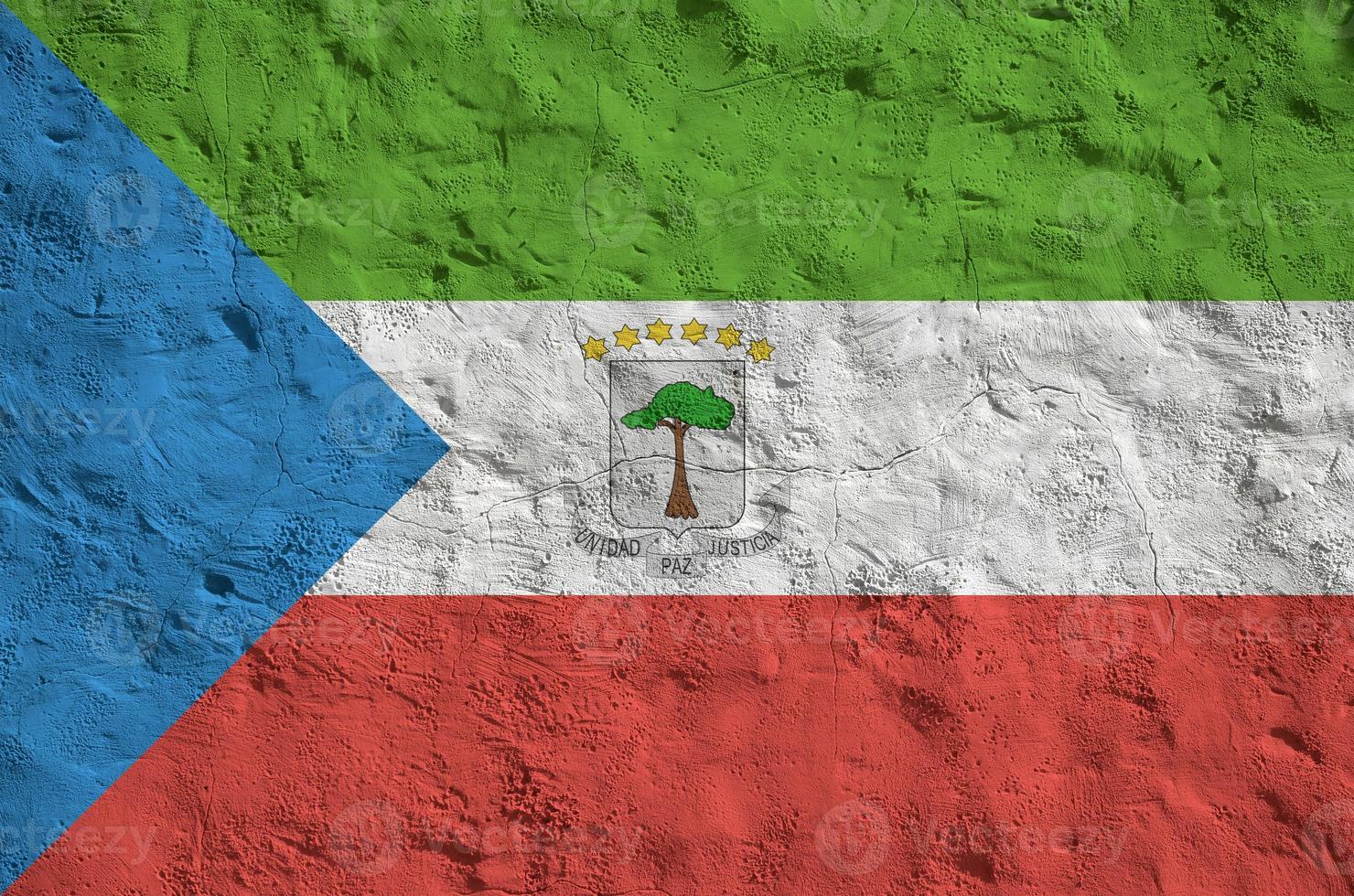 Equatorial Guinea flag depicted in bright paint colors on old relief plastering wall. Textured banner on rough background photo