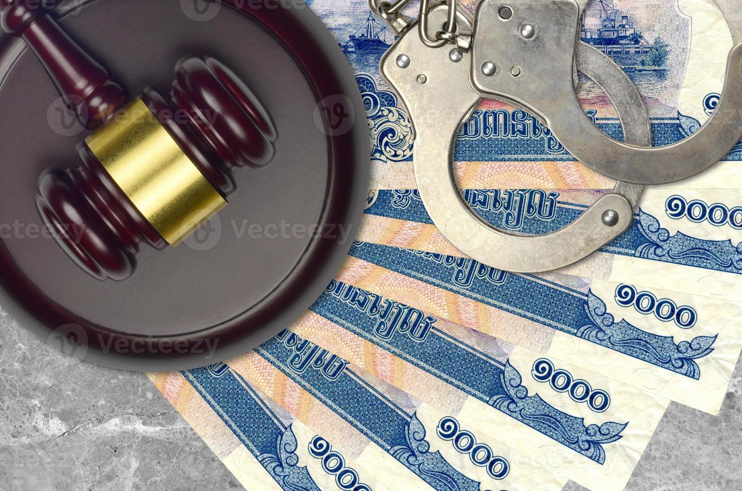1000 Cambodian riels bills and judge hammer with police handcuffs on court desk. Concept of judicial trial or bribery. Tax avoidance photo