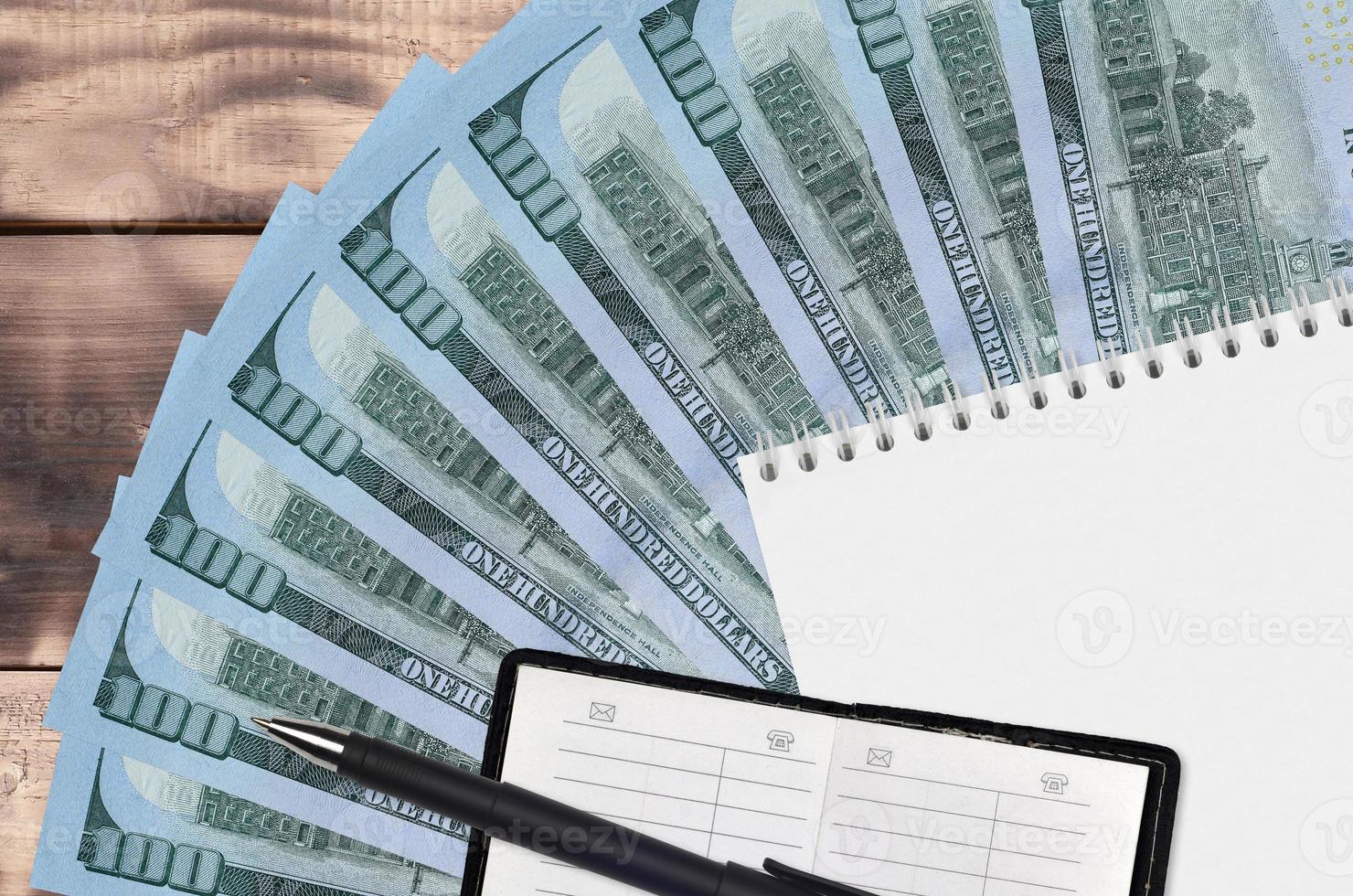 100 US dollars bills fan and notepad with contact book and black pen. Concept of financial planning and business strategy photo