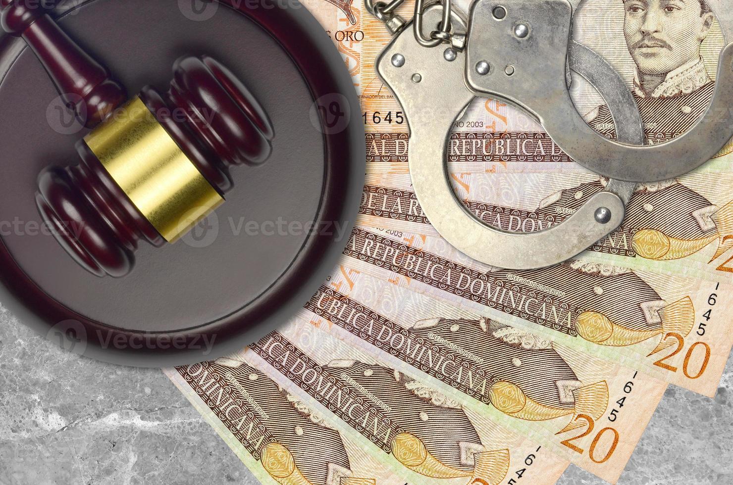 20 Dominican peso bills and judge hammer with police handcuffs on court desk. Concept of judicial trial or bribery. Tax avoidance photo