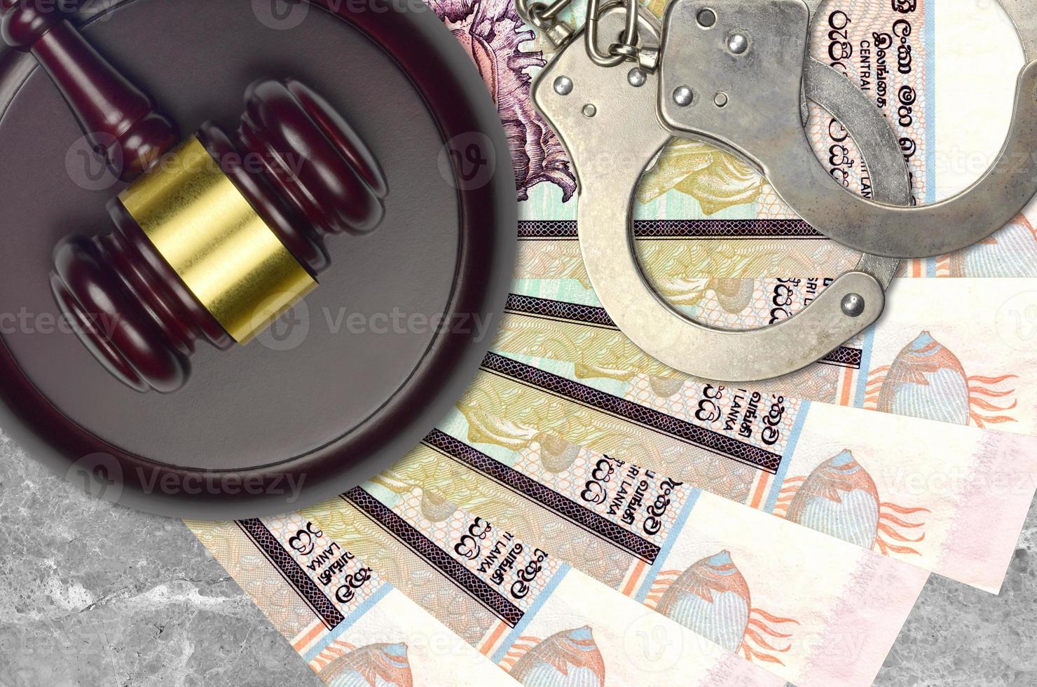 20 Sri Lankan rupees bills and judge hammer with police handcuffs on court desk. Concept of judicial trial or bribery. Tax avoidance photo