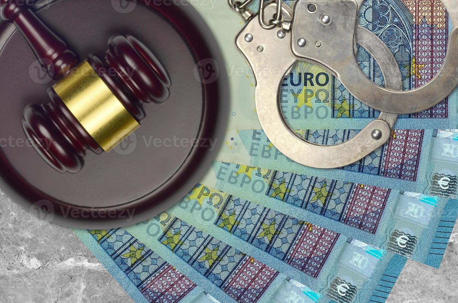 20 euro bills and judge hammer with police handcuffs on court desk. Concept of judicial trial or bribery. Tax avoidance photo
