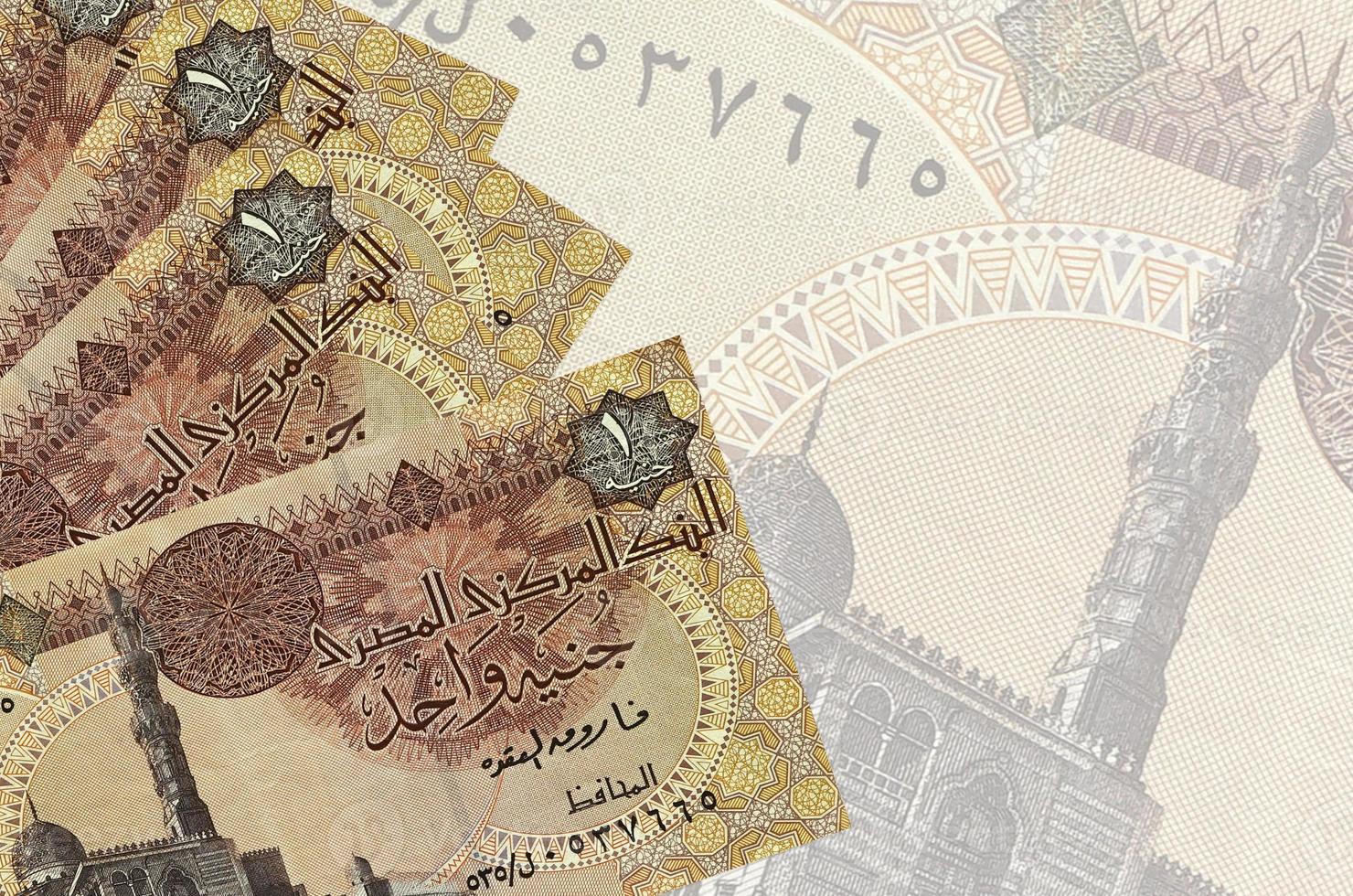 1 Egyptian pound bills lies in stack on background of big semi-transparent banknote. Abstract business background photo