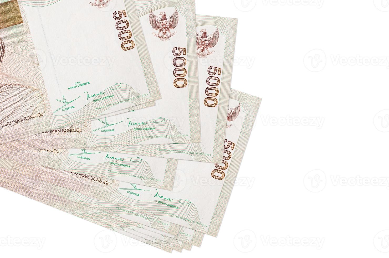 Los billetes de 5000 rupias indonesias se encuentran en un pequeño grupo o en un paquete aislado en blanco. maqueta con espacio de copia. negocios y cambio de moneda foto