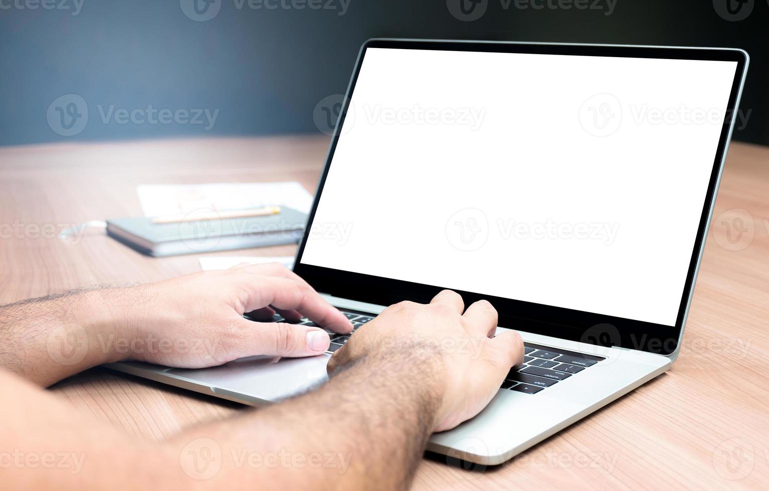 Businessman hand pressing keyboard laptop with mock up sales summary slide show presentation on display laptop and coffee cup on table in meeting room photo