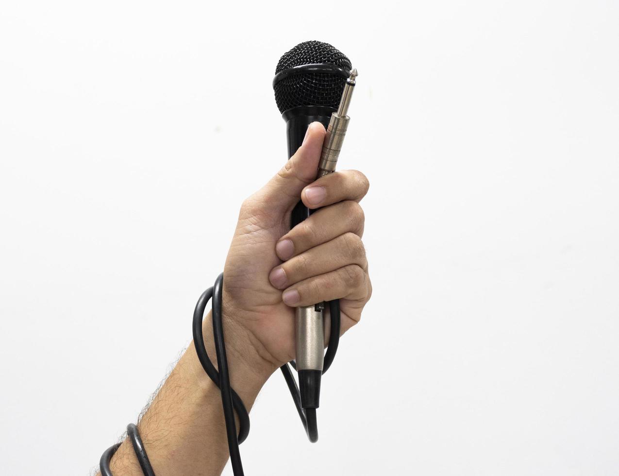 Hand holding a microphone isolated on white background photo